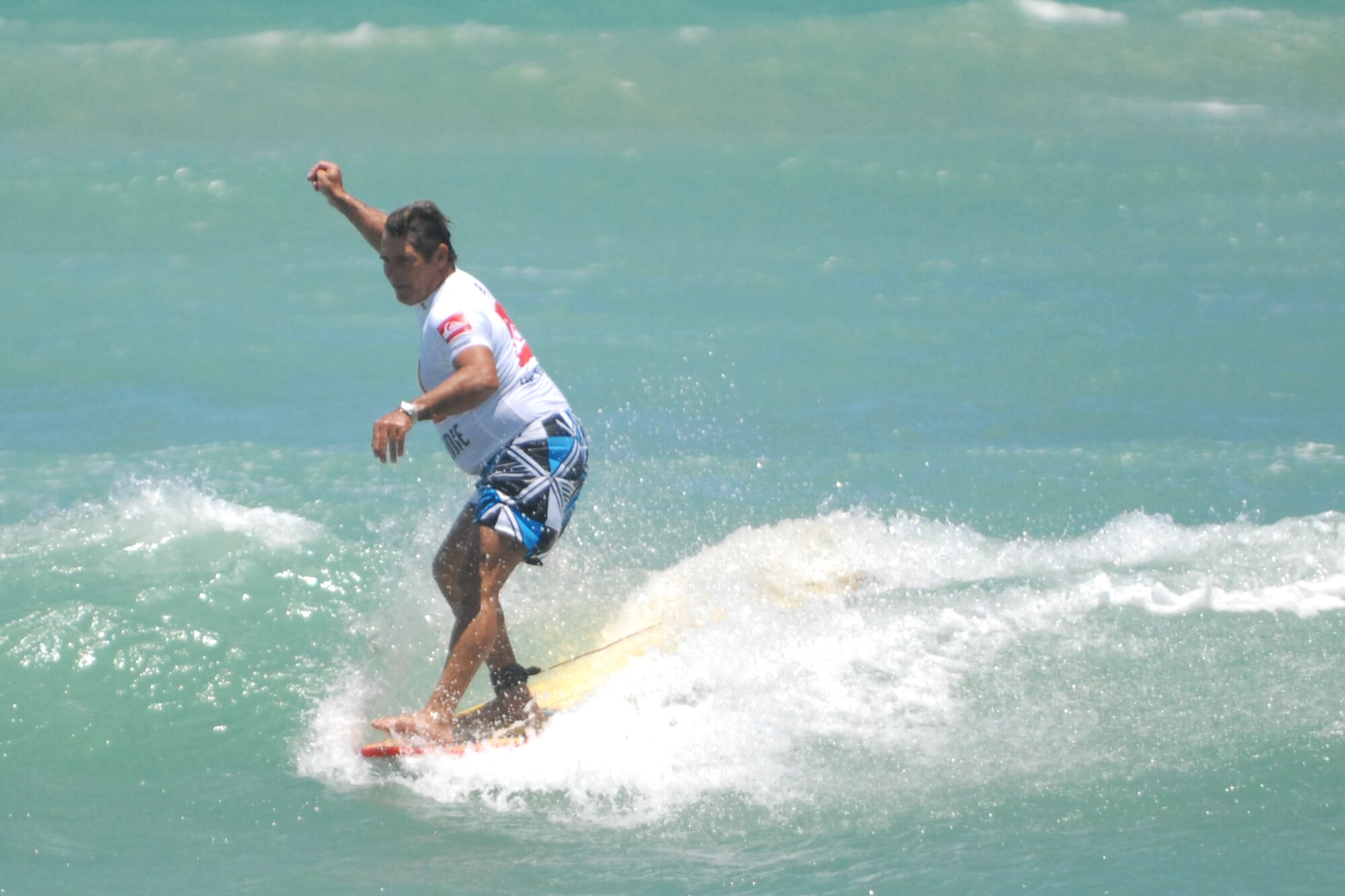 KALAELOA, Hawaii -- Les "Buster" Kellum, 15th Airlift Wing multimedia manager, waxes his surf board June 20 at White Pains Beach. Kellum, a retired Air Force chief master sergeant, won in the 50 and over Open Longboard division. He was also awarded third place in the 30 and over division and fourth place in the 40 and over. Kellum has been surfing more than 30 years and continues to rides the waves because he says it keep him young. The annual surfing competition featured more than 200 active duty, guard, Reserve, retirees and their families from the Air Force, Army, Navy, Marines and Coast Guard. (U.S. Air Force photos/Staff Sgt. Mike
Meares)