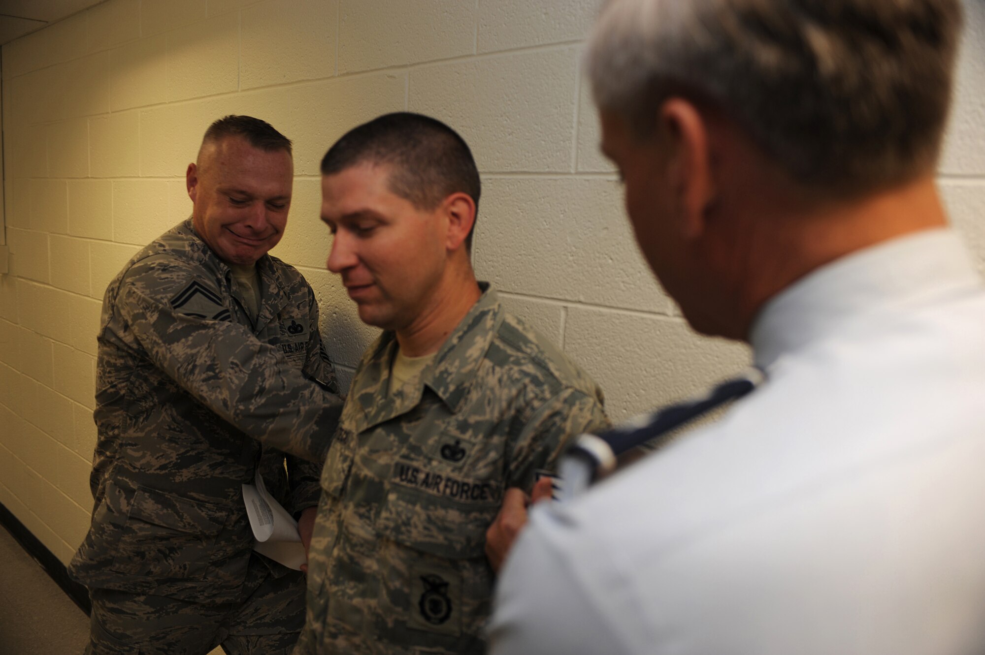 Major Gen. Kip Self (right), U.S. Air Force Expeditionary Center commander, and Senior Master Sgt. Scott Pepper, 421st Combat Training Squadron superintendent, tack technical sergeant stripes on Staff Sgt. John Matecki, also with the 421st CTS, on June 18 at the center.  Twelve Airmen from the Expeditionary Center were selected for E-6 stripes. (U.S. Air Force Photo/Staff Sgt. Nathan G. Bevier) 