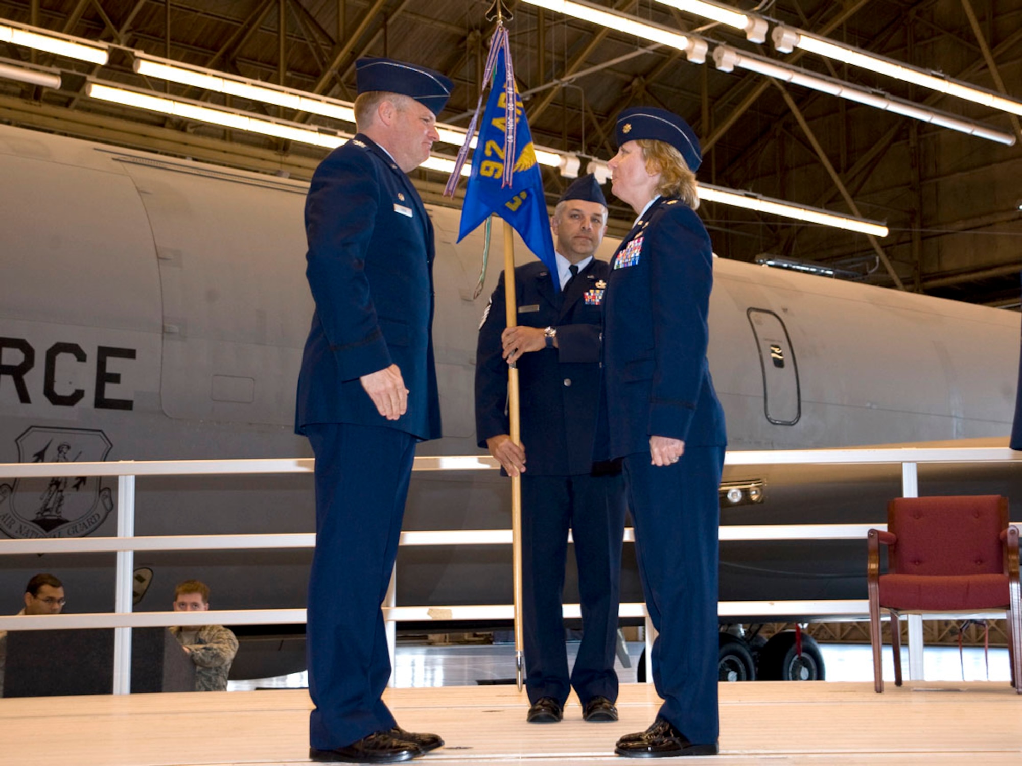 Col. John Tobin, 92nd Maintenance Group commander, prepares to hand Maj. Jill Murphy, 92nd Maintenance Operations Squadron commander, the guidon during the change of command ceremony in building 2050 June 22. (U.S. Air Force photo / Staff Sgt. JT May)