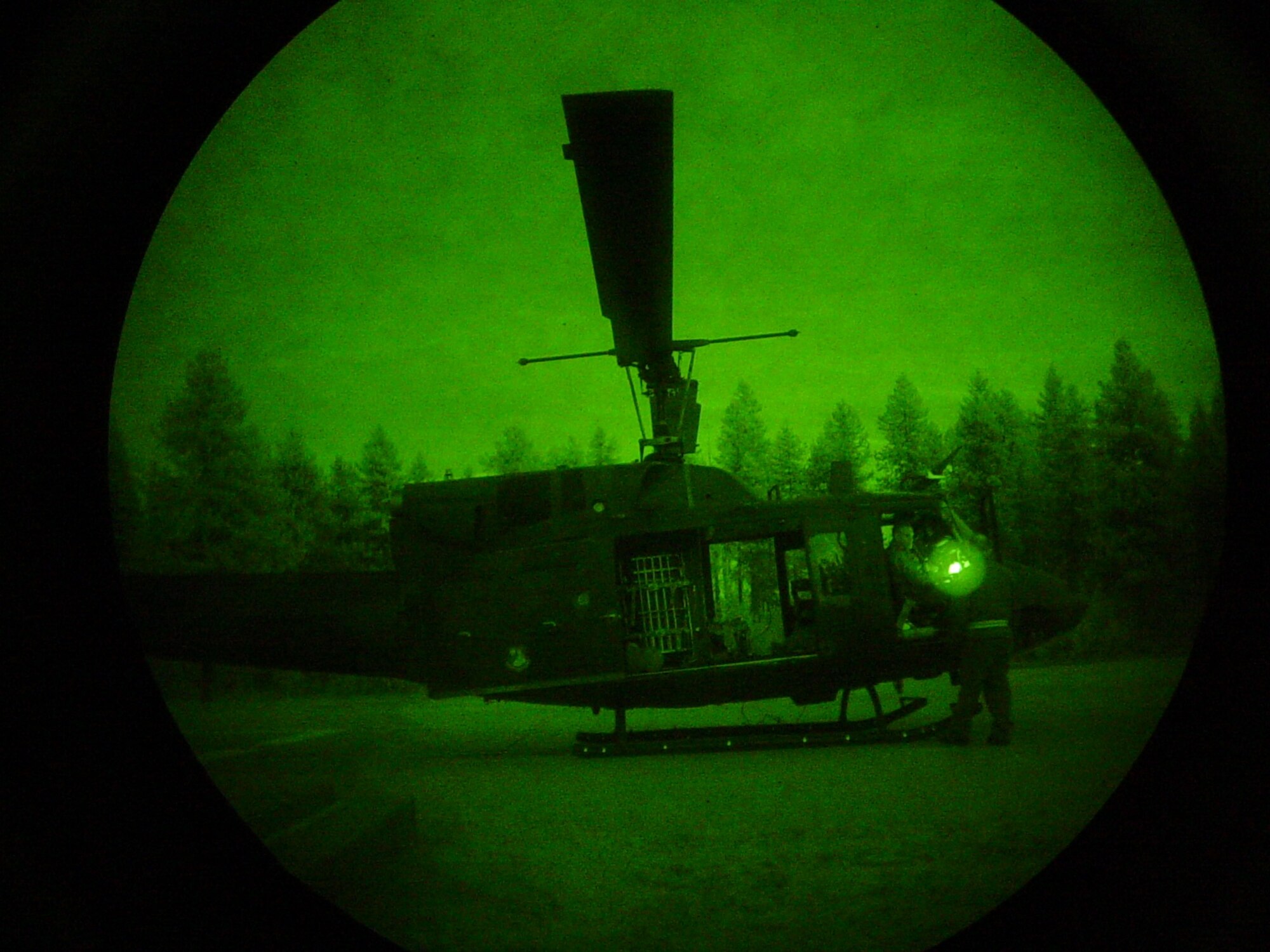 A look through a pair of night vision goggles at the UH-1N Huey helicopter. (U.S. Air Force photo/Staff Sgt. Jacob Bragg)