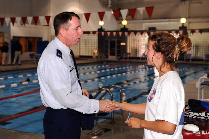 OFFUTT AIR FORCE BASE Neb. -- Col. John N.T. Shanahan, 55th Wing commander, presents Rachel Buckner, a lifeguard with the 55th Force Support Squadron, with a his coin at the Offutt Field House June 26.  Ms. Buckner received the coin for saving a six-year-old girl at the Capehart Pool June 23. U.S. Air Force Photo by Josh Plueger