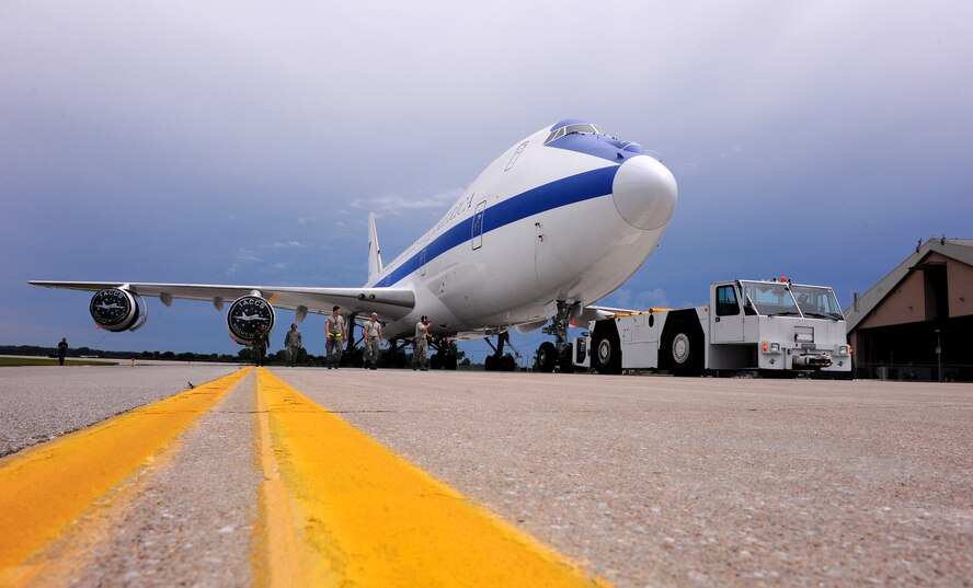 OFFUTT AIR FORCE BASE Neb.,-- An E-4B aircraft an emergency mobile command and control center, is towed out of it's hangar at the east end of Offutt's runway June 17. The E-4B serves as the National Airborne Operations Center for the president,  secretary of defense and the Joint Chiefs of Staff. If needed, the E-4B can provide a command, control and communications center to direct U.S. forces, execute emergency war orders and coordinate actions by civil authorities. U.S. Air Force Photo by Josh Plueger
