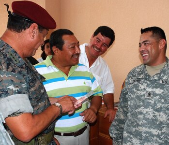 POPTUN, Guatemala - U.S. Army 1st Sgt. Jorge Ortiz shows Guatemala Army Col. Alvarado Castillo and Poptun Mayor Angel Kelkan Ochoa some children’s vitamins during a medical readiness and training exercise in Poptun June 25. The vitamins are handed out as part of a preventive medicine course all patients must attend prior to receiving care. Twenty-three members of Joint Task Force-Bravo, based at Soto Cano Air Base, Honduras, teamed up with the Guatemalan Army, Military Group, and Ministry of Health to provide care to residents of the Poptun area. (U.S. Air Force photo/Tech. Sgt. Mike Hammond)