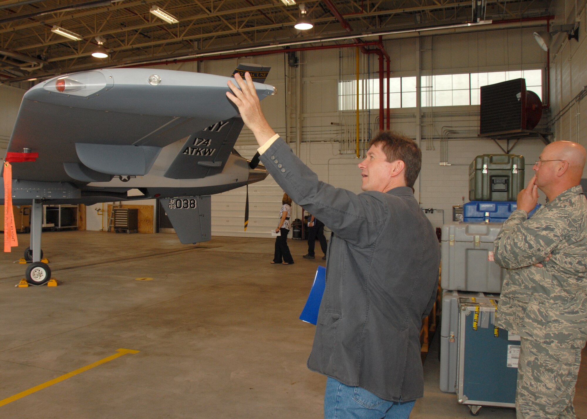 Post-Standard reporter Rick Moriarty touches the wing of an MQ-9 Reaper Unmanned Aerial Vehicle at Hancock Field in Syracuse, NY, on 26 June 2009. Moriarty was invited as part of the Media Day event introducing the new Unmanned Aerial System mission of the 174th Fighter Wing. (US Air Force photo by Tech. Sgt. Jeremy M. Call/Released)