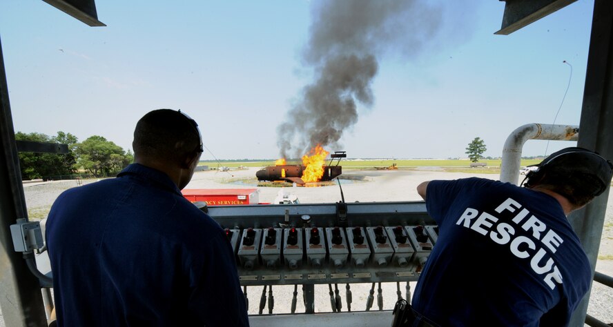 MOODY AIR FORCE BASE, Ga. -- Charlie Johnson, 23rd Civil Engineer Squadron assistant chief of training, and Rodney McKinney, 23rd CES crew chief, ignite flames on the HC-130P to mark the start of a training exercise here June 25. They set the fire on different sides of the aircraft to present Airmen with different scenarios. (U.S. Air Force photo by Airman 1st Class Joshua Green)
