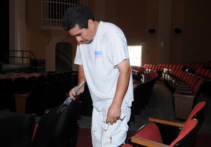 Arturo Nino, a contractor with Converse Painting, places a final coat on the theatre seats June 26. Officials expect renovations on the theatre to wrap up in mid-July. (U.S. Air Force photo by Don Lindsey)
