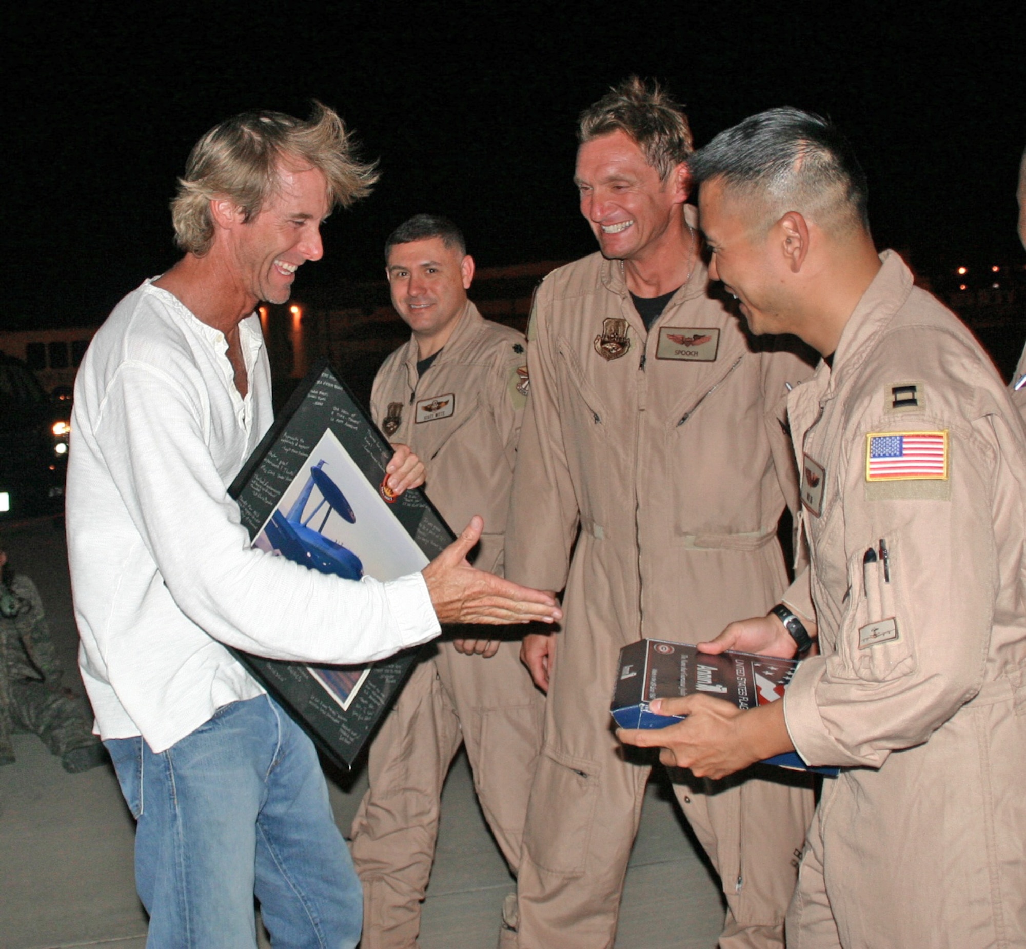 Lt. Col. Jimmy Warren and Capt. Thomas Ikehara present Michael Bay with a framed picture of the E-3 Sentry and a flag flown on the jet during a combat sortie as a token of appreciation after filming on an E-3. Mr. Bay is the director of "Transformers: Revenge of the Fallen." (Courtesy photo) 
