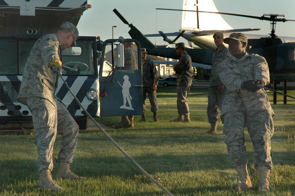 Senior Airman Kyle Adams and Airman 1st Class Daniel James, 341st Logistics Readiness Squadron vehicle operators, pull wrecker tow cables toward a 1962 transporter erector June 3 at the Malmstrom Museum. The TE was towed to the allied trades shop to be disassembled, sanded and repainted. The allied trade's staff will work on the vehicle as time permits, and expect it will be done in about one year. (U.S. Air Force photo/Senior Airman Dillon White) 