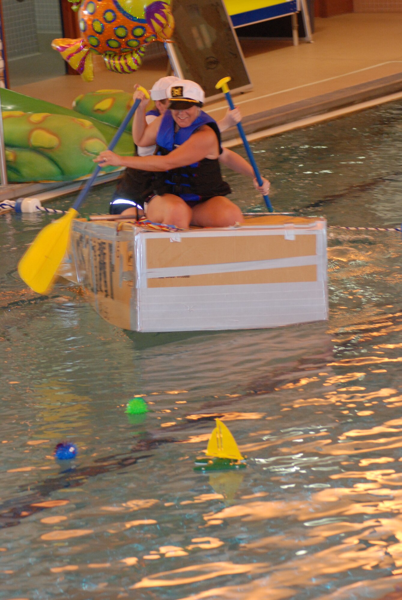 Staff Sgt. Alicia Wallace and Master Sgt. Shari Schad, both from Twentieth Air Force, paddle Burg’s Barge across the pool. The team made it safely across and back, earning the most creative award.