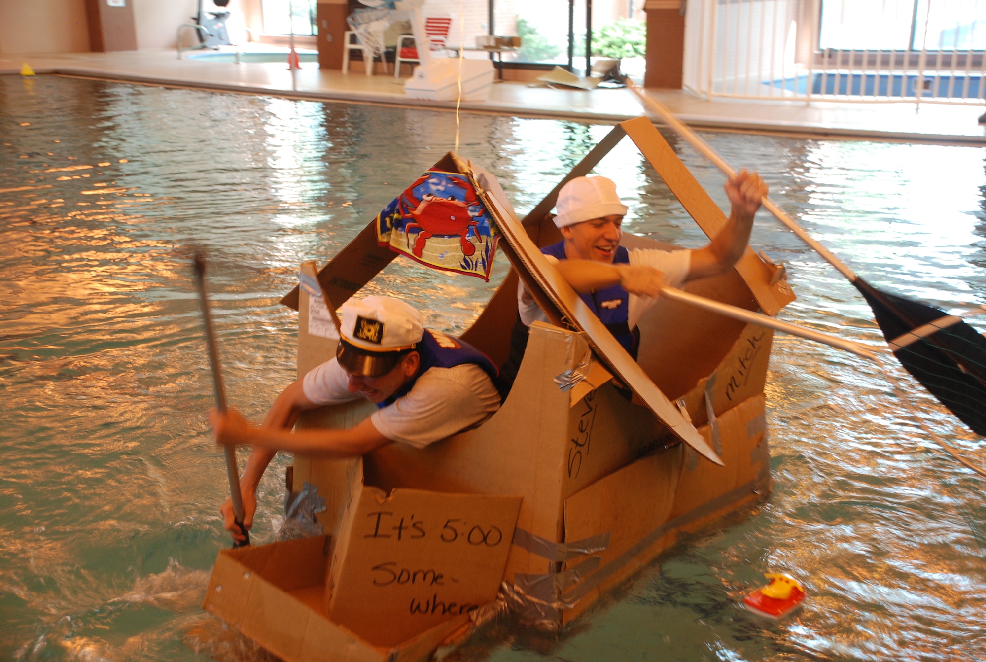 F.E. WARREN AIR FORCE BASE, Wyo. - Airmen 1st Class Steven Rosales and Mitch Roesch, both from the 90th Force Support Squadron, paddle their houseboat titled ‘In It For The Booty’ across the aquatic center’s pool for the Summer Rage Engage water event June 18. This team won the event with a time of one minute and four seconds. (Photo by Airman 1st Class Jennifer Viveiros.)