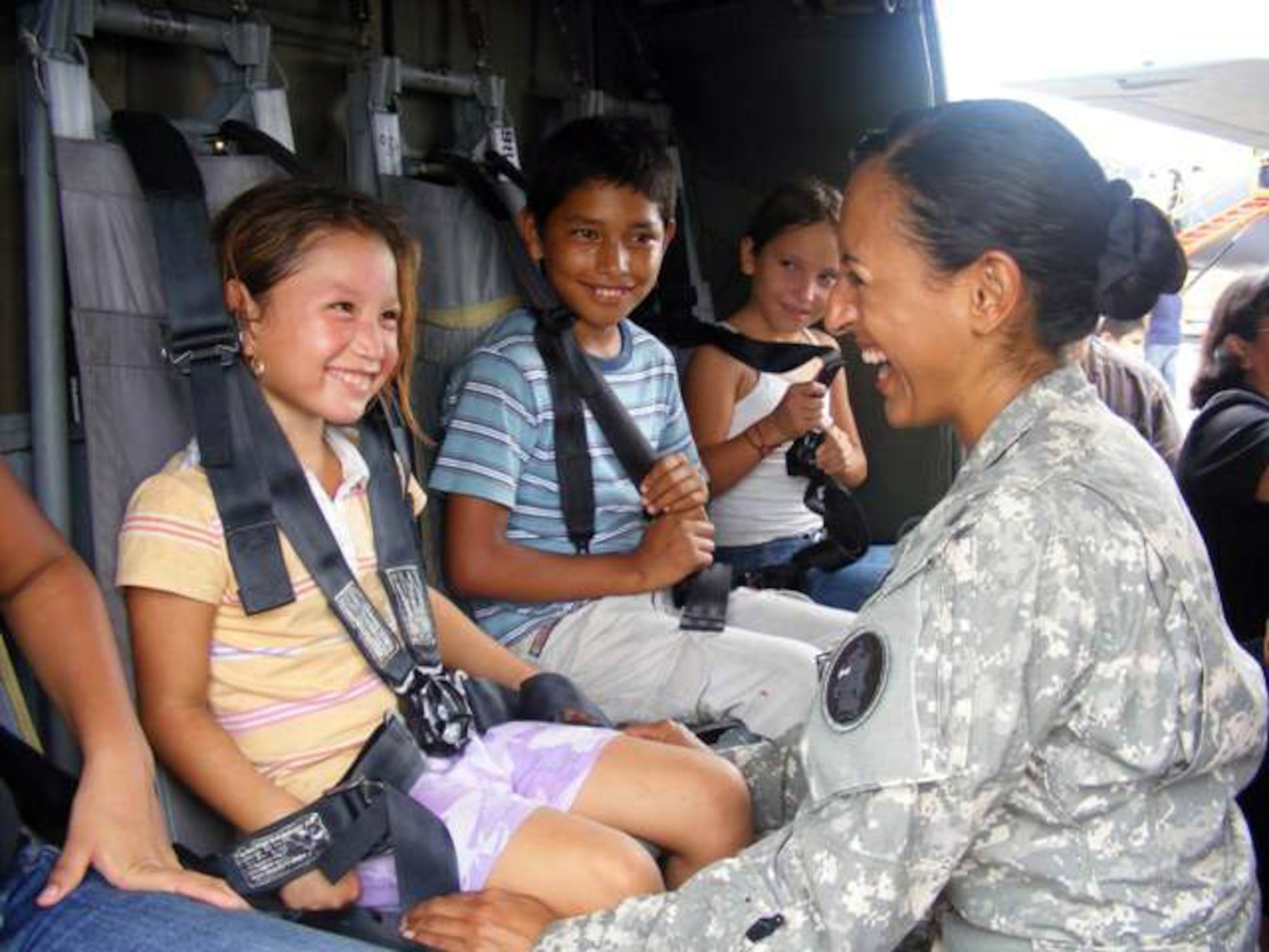 Army Capt. Vijay Gallardo jokes with children during a static helicopter display at an airshow June 21 at San Pedro Sula, Honduras. More than 30 Airmen and five Soldiers participated at the international airshow. Captain Gallardo is a UH-60 Black Hawk pilot assigned to Joint Task Force-Bravo. (U.S. Air Force photo/Capt. Candace Park) 
