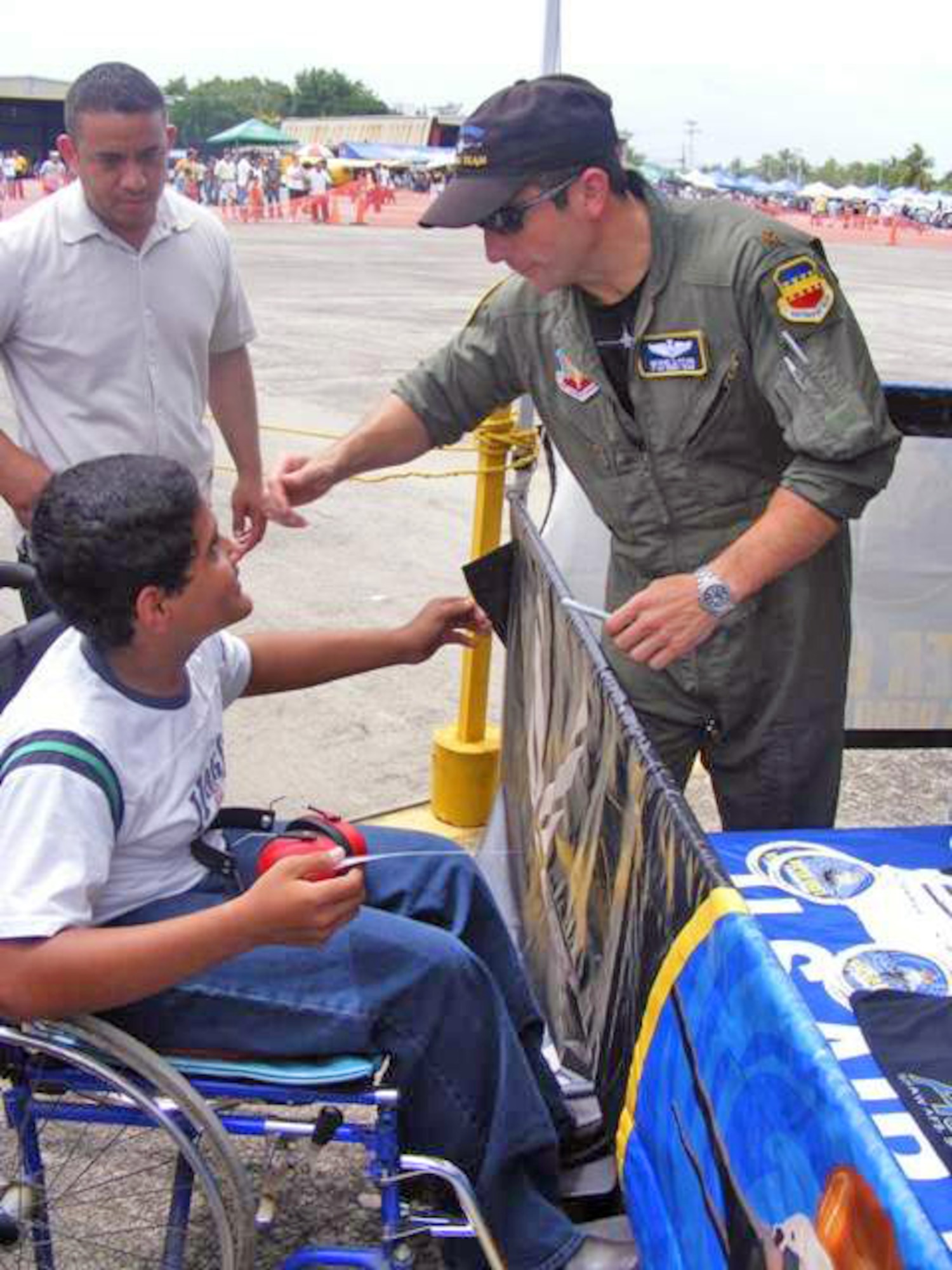 Maj. George Clifford greets a Honduran boy after his aerial demonstration at an airshow June 20 at San Pedro Sula, Honduras. More than 30 Airmen participated at the international airshow. Major Clifford is a Viper East F-16 Demonstration Team pilot. (U.S. Air Force photo/Capt. Candace Park) 
