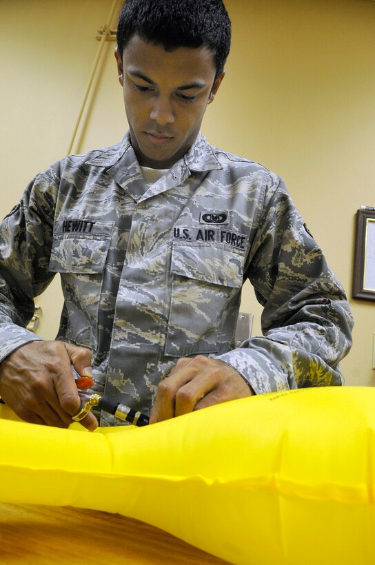 Airman 1st Class Devin Hewitt, 28th Operations Support Squadron aircrew flight equipment apprentice, uses an air hose to test the reliability of an inflation cell for a life preserver unit here, June 25. Airman Hewitt uses various types of testing equipment such as the air hose to conduce reliability testing of all aircrew flight equipment. (U.S. Air Force photo by Airman 1st Class Corey Hook)