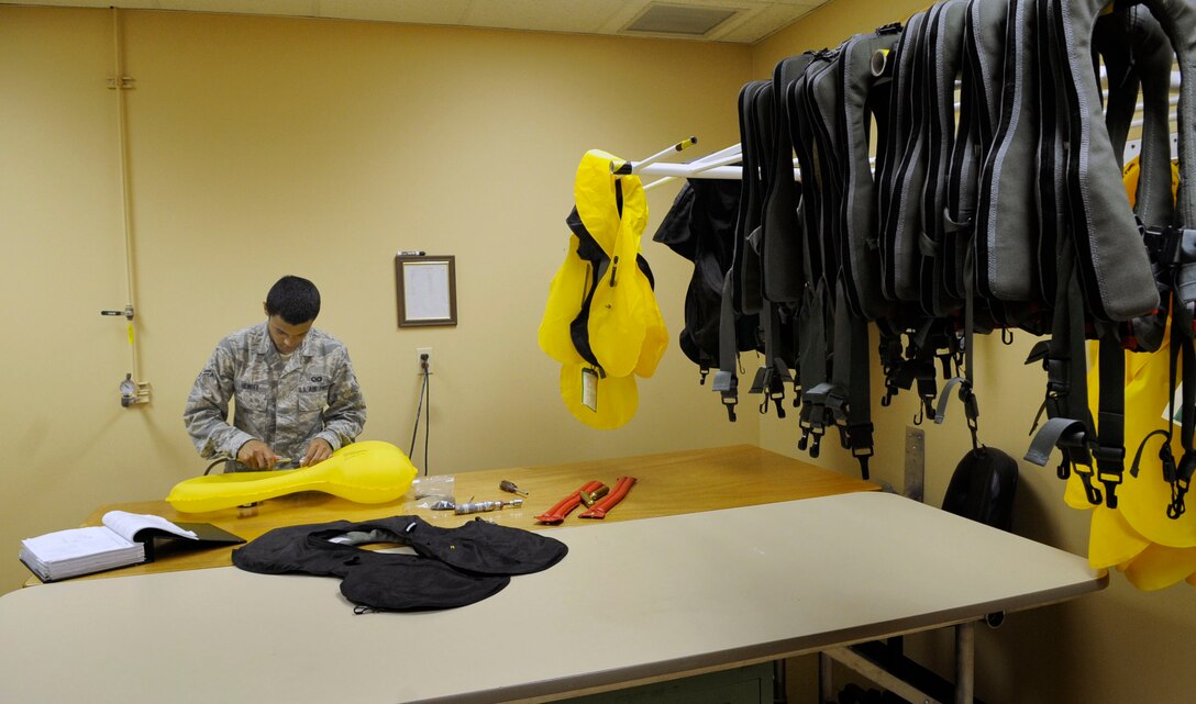 Airman 1st Class Devin Hewitt, 28th Operations Support Squadron aircrew flight equipment apprentice, uses an air hose to test the reliability of an inflation cell for a life preserver unit here, June 25. Airman Hewitt is responsible for inspecting, maintaining, packing and adjusting aircrew flight equipment. (U.S. Air Force photo by Airman 1st Class Corey Hook)