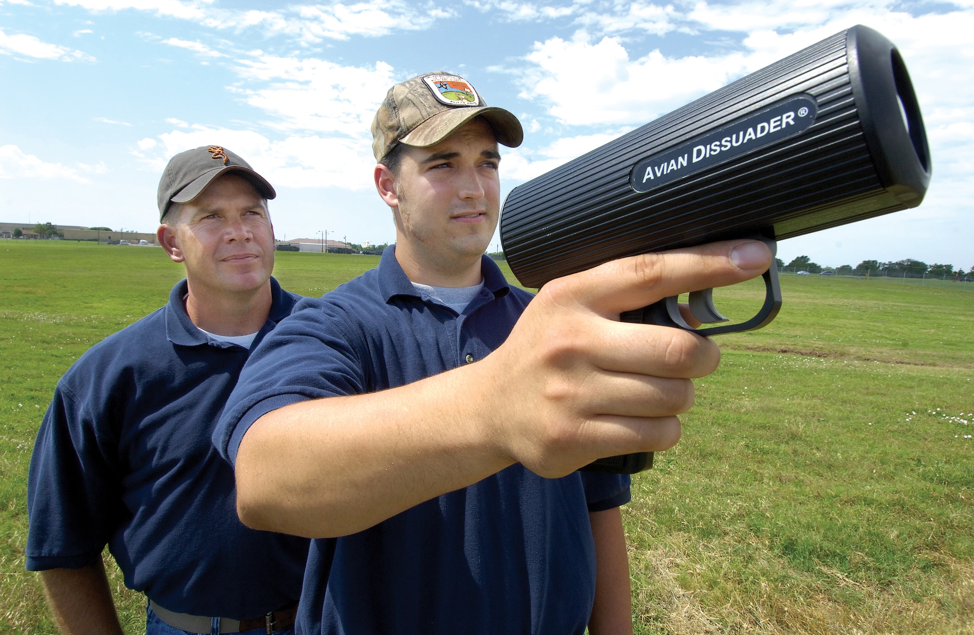Birds up to one-half mile away will flee an area when the Avian Dissuader’s red laser beam is flashed their way. United States Department of Agriculture and Wildlife Services biologist Clarke Baker, back, and wildlife specialist Matt Gage use the device in their non-lethal arsenal to keep birds away from Tinker, protecting aircraft from bird strikes. (Air Force photo by Margo Wright)