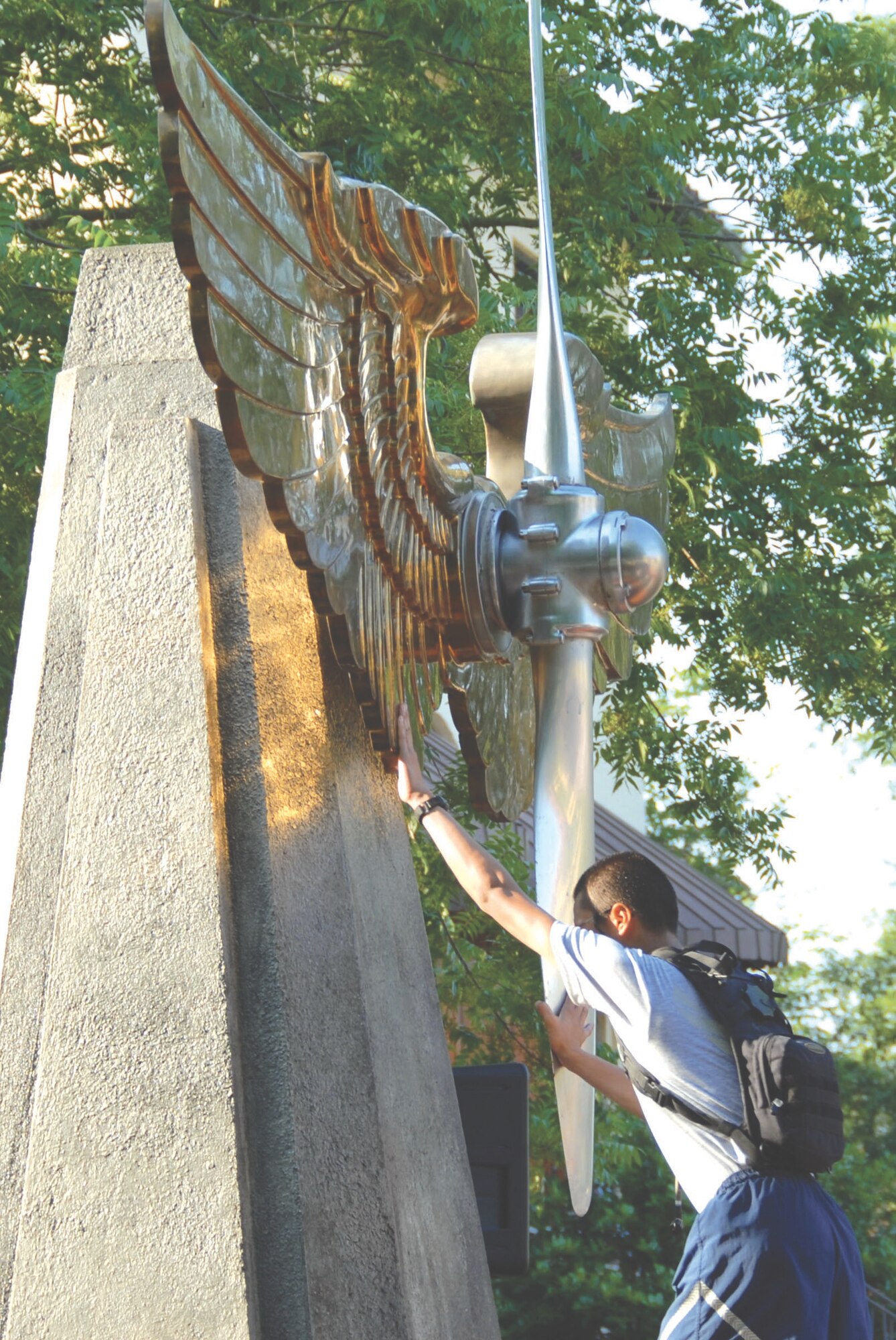 An Air Force ROTC cadet touches Maxwell's monument to the "Prop and Wings" in a ceremony June 19 that signified the cadets acceptance into the "long blue line of the Air Force." The cadets wear the prop and wings emblem after completing the arduous first phase of officer training. Air Education and Training Command Commander Gen. Stephen Lorenz established the ceremony at Maxwell in 2007 while he commanded Air University. He attended the Maxwell ceremony June 19. The prop and wings emblem was first worn by aviation cadets in 1917. Today the emblem is worn by cadets at the Air Force Academy and Officer Training School in addition to cadets in Air Force ROTC. (U.S. Air Force photo/Jamie Pitcher)