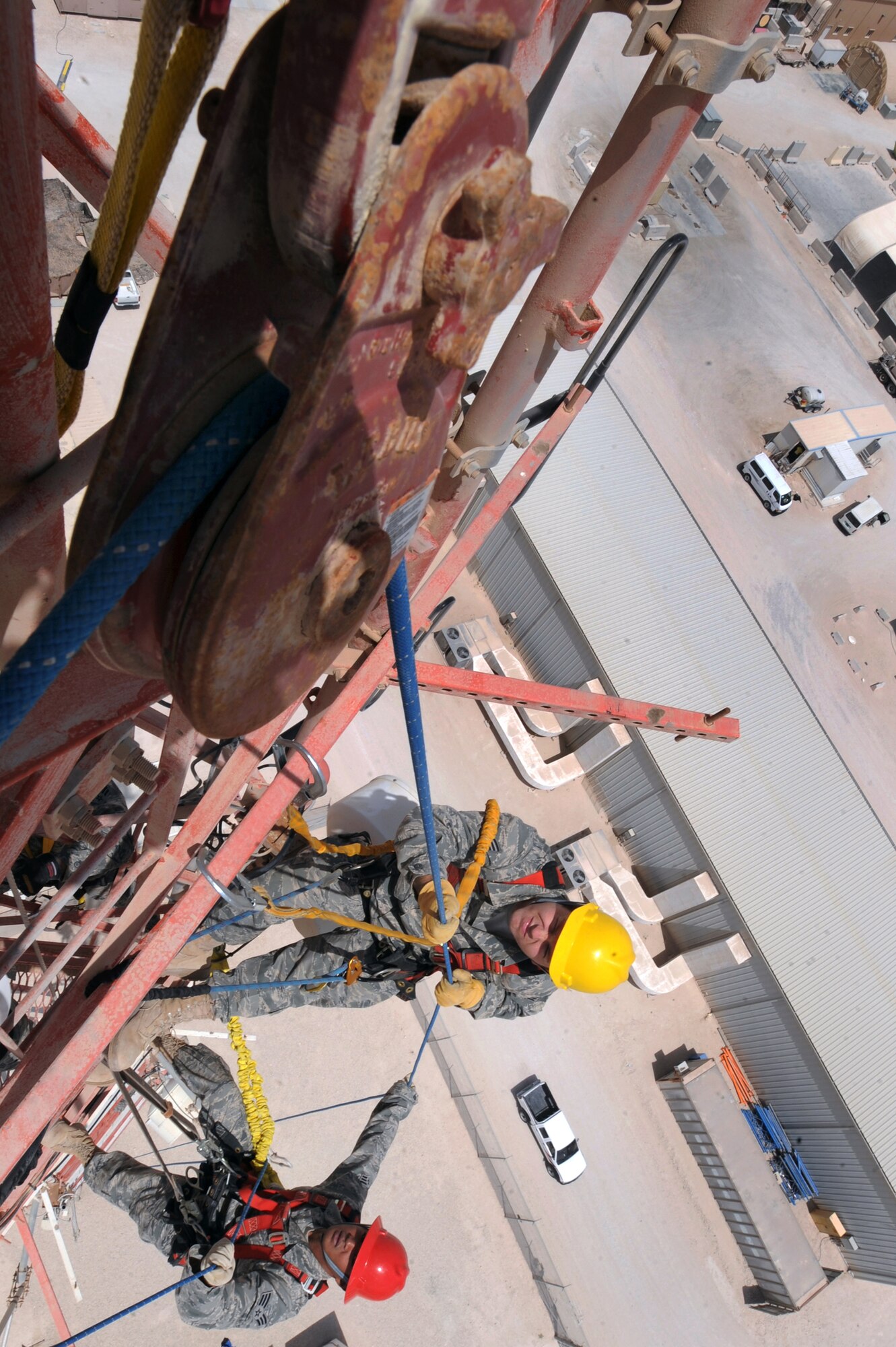 Senior Airman Richard Coyle, and Senior Airman Jonathan Tacto, both cable and antenna maintenance technicians with the 379th Expeditionary Communications Squadron navigate a rope through a pulley system to bring up their tool bag during a preventive maintenance inspection on an antenna tower, June 23, 2009, in an undisclosed location in Southwest Asia.  Tools and other supplies are brought up via the rope system allowing personnel to spend more time working on equipment instead of traversing the tower.  The 175 ft communications tower holds multiple antennas and provides support for a variety of amenities and services on base, from Armed Forces Network channels to cellular phone reception.  Airman Coyle is native to Converse, Texas and is deployed from Langley Air Force Base, Va. while Airman Tacto hails from Kailua, Hawaii and is deployed from Kapaun Air Station, Germany, both in support of Operations Iraqi and Enduring Freedom and Combined Joint Task Force - Horn of Africa.(U.S. Air Force Photo by Staff Sgt. Joshua Garcia/released)