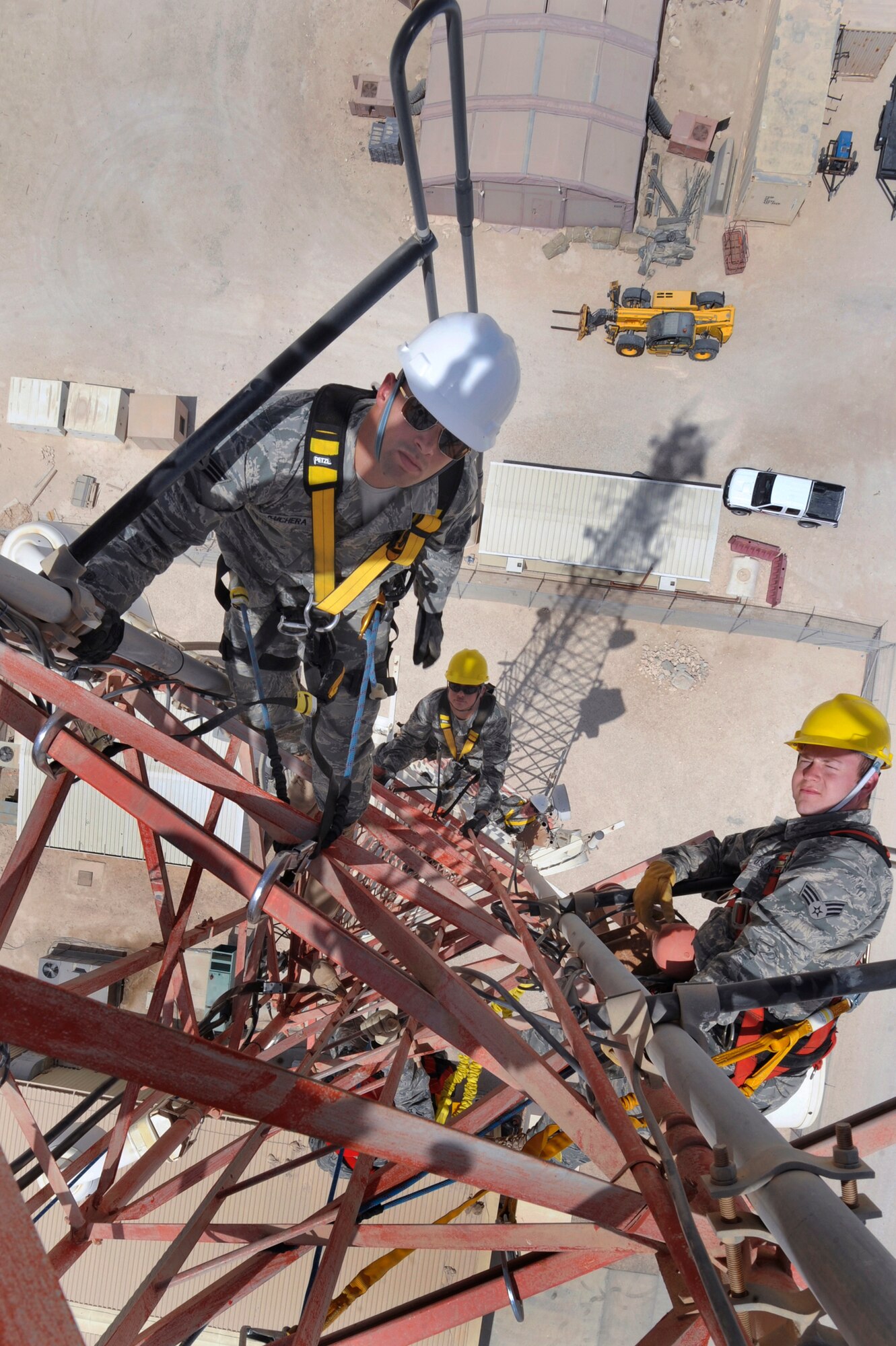 Members of the 379th Expeditionary Communications Squadron Cable and Antenna Maintenance Shop, take a break after getting into position on a 175ft communications tower to perform preventive maintenance on the attached antennas, June 23, 2009, in and undisclosed location in Southwest Asia.  The tower holds multiple antennas and provides support for a variety of amenities and services on base, from Armed Forces Network channels to cellular phone reception.  The team includes Senior Airman Matthew "Kuch" Kuchera who is from Medford, N.J. and is deployed from Langley Air Force Base, Va.  Airman 1st Class Jeremy Lowe (center) who is from San Bernardino, Calif. and is deployed from Lackland Air Force Base, Texas and Senior Airman Richard Coyle who is from Converse, Texas and is deployed from Langley Air Force Base, Va.  All members are deployed in support of Operations Iraqi and Enduring Freedom and Combined Joint Task Force - Horn of Africa.  (U.S. Air Force Photo by Staff Sgt. Joshua Garcia/released) 