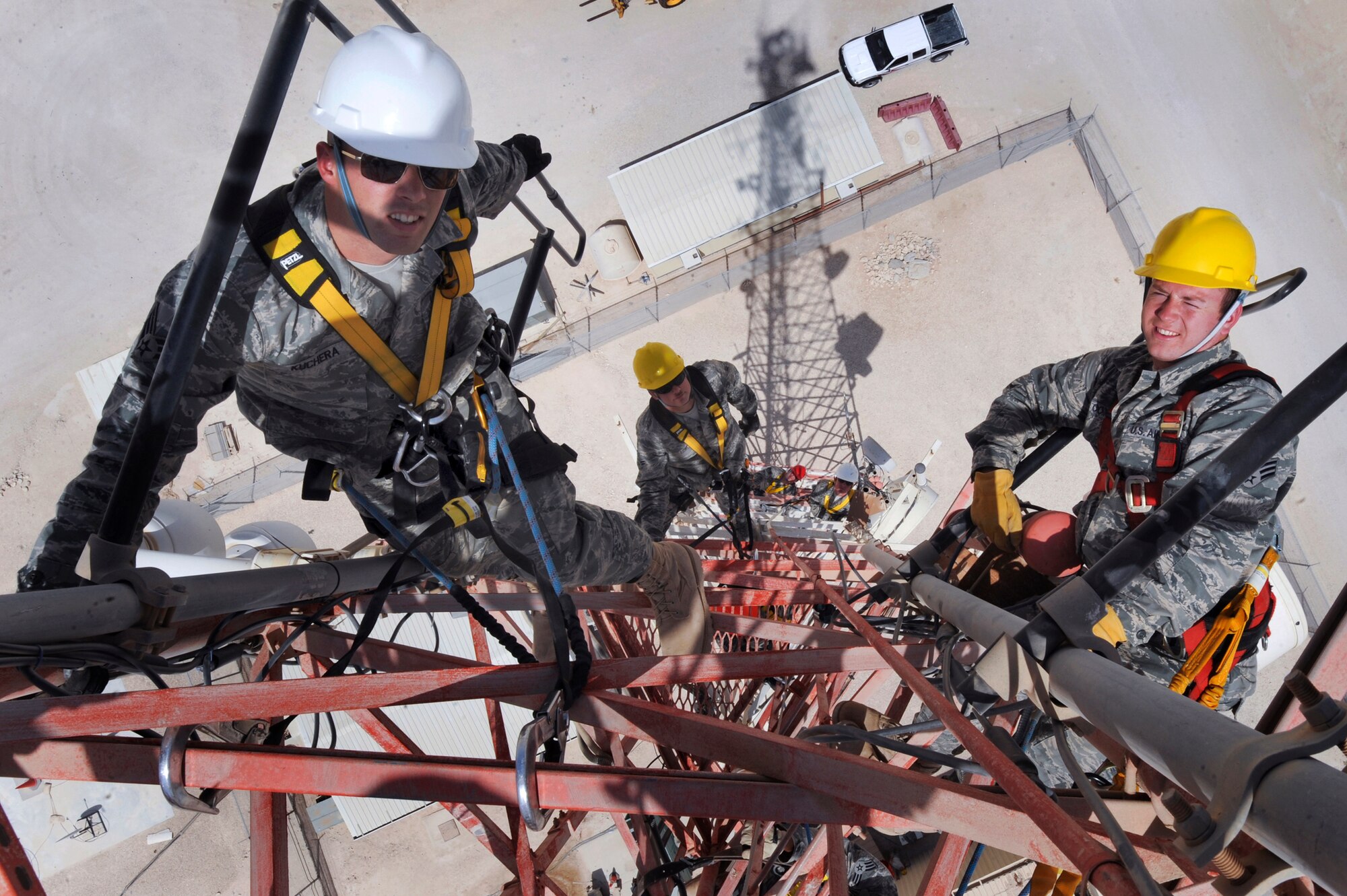 Members of the 379th Expeditionary Communications Squadron Cable and Antenna Maintenance Shop, take a break after getting into position on a 175ft communications tower to perform preventive maintenance on the attached antennas, June 23, 2009, in and undisclosed location in Southwest Asia.  The tower holds multiple antennas and provides support for a variety of amenities and services on base, from Armed Forces Network channels to cellular phone reception.  The team includes Senior Airman Matthew "Kuch" Kuchera who is from Medford, N.J. and is deployed from Langley Air Force Base, Va.  Airman 1st Class Jeremy Lowe (center) who is from San Bernardino, Calif. and is deployed from Lackland Air Force Base, Texas and Senior Airman Richard Coyle who is from Converse, Texas and is deployed from Langley Air Force Base, Va.  All members are deployed in support of Operations Iraqi and Enduring Freedom and Combined Joint Task Force - Horn of Africa.  (U.S. Air Force Photo by Staff Sgt. Joshua Garcia/released) 
