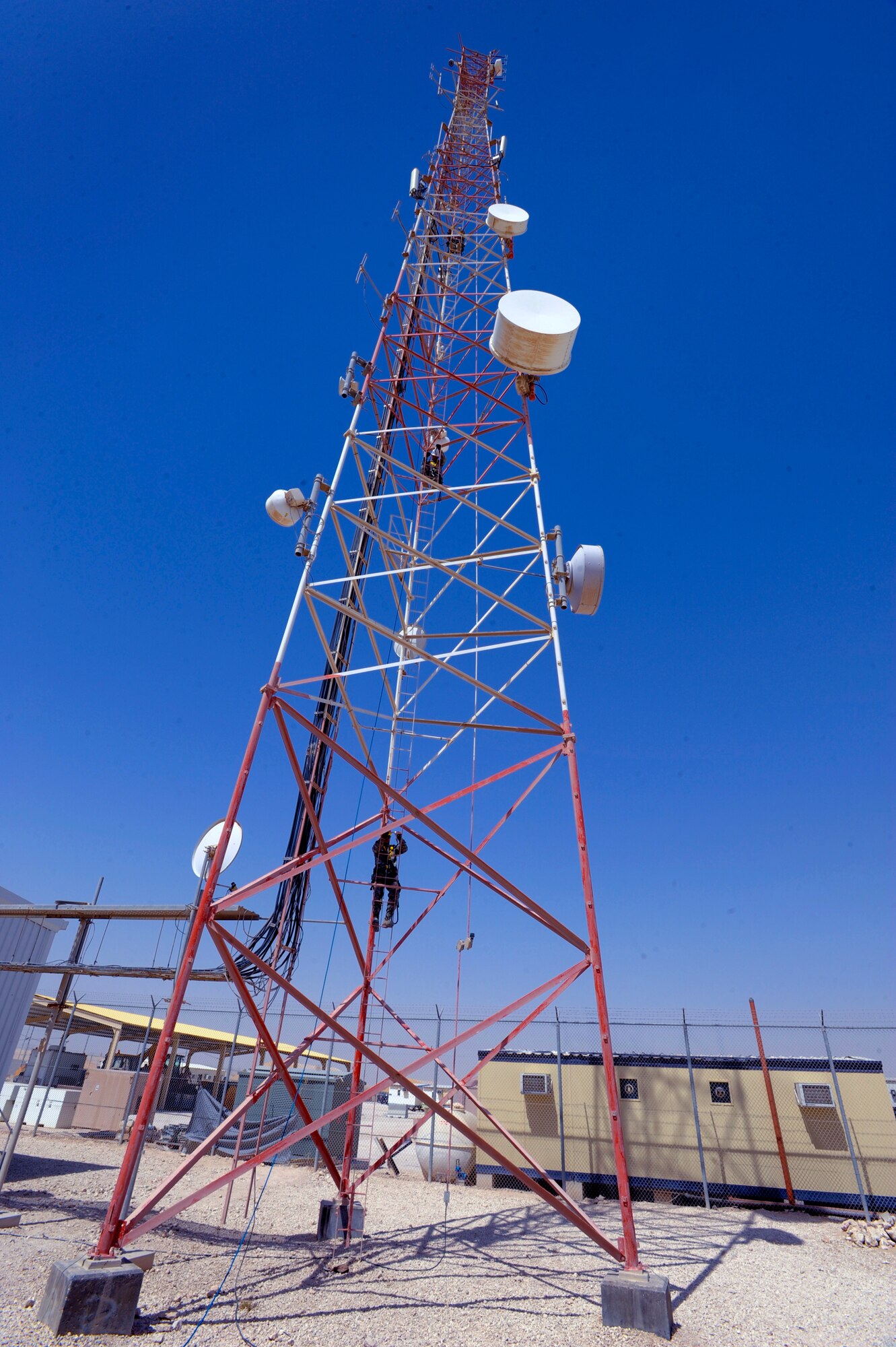 Members of the 379th Expeditionary Communications Squadron Cable and Antenna Maintenance Shop, climb a 175ft communications tower to perform preventive maintenance on the attached antennas, June 23, 2009, in and undisclosed location in Southwest Asia. The tower holds multiple antennas and provides support for a variety of amenities and services on base from Armed Forces Network channels to cellular phone reception.  All members are deployed in support of Operations Iraqi and Enduring Freedom and Combined Joint Task Force - Horn of Africa.  (U.S. Air Force Photo by Staff Sgt. Joshua Garcia/released)