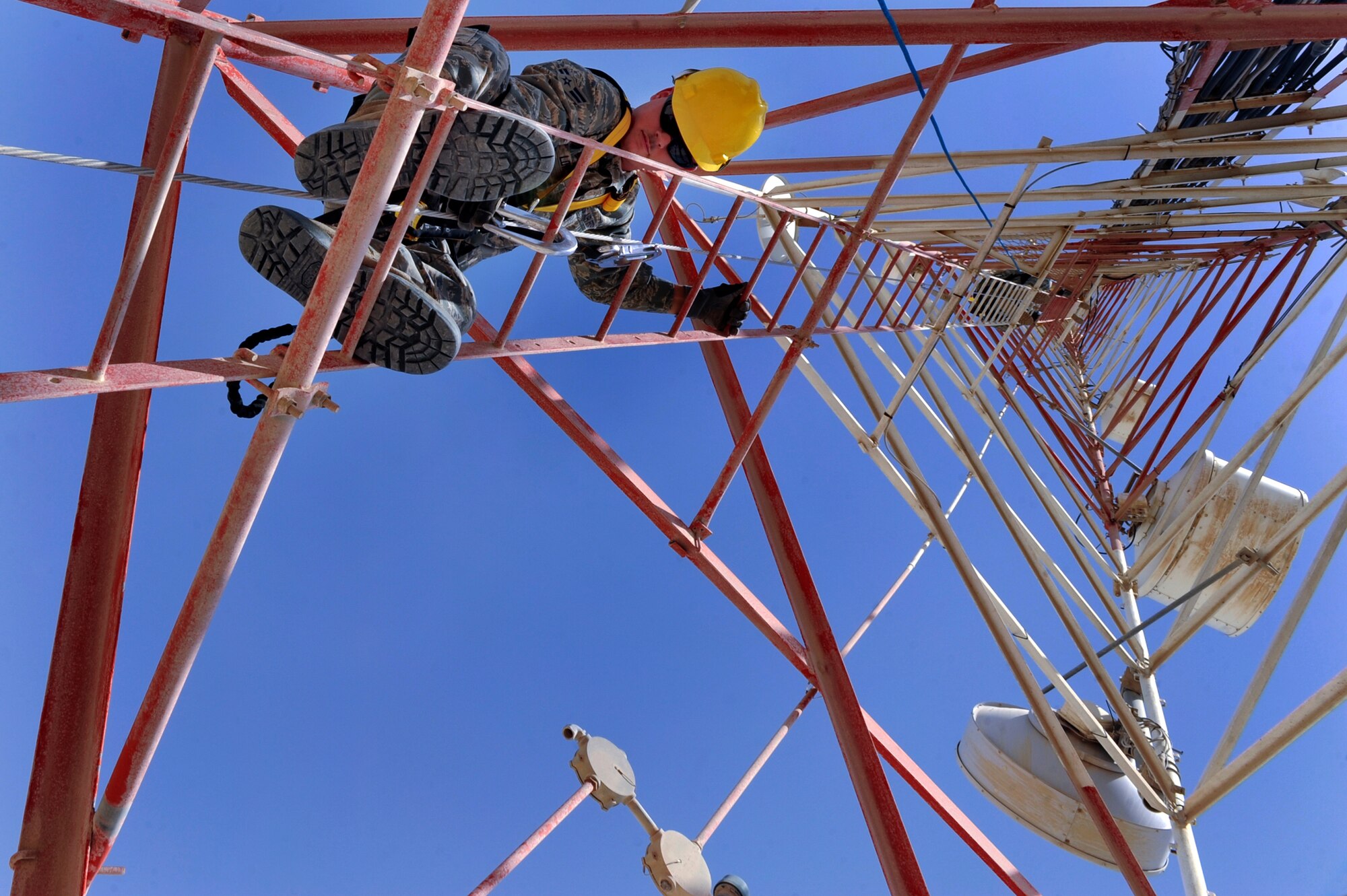 Airman 1st Class Jeremy Lowe, a cable and antenna maintenance technician with the 379th Expeditionary Communications Squadron, climbs up a 175ft communications tower in order to perform preventative maintenance on the antennas, June 23, 2009, in an undisclosed location in Southwest Asia.  A safety harness is used to ensure Airman Lowe has three points of contacts with the tower at all times. The tower holds multiple antennas and provides support for a variety of amenities and services on base from Armed Forces Network channels to cellular phone reception.  Airman Lowe is native to San Bernardino, Calif. and is deployed from Lackland Air Force Base, Texas, in support of Operations Iraqi and Enduring Freedom and Combined Joint Task Force - Horn of Africa.  (U.S. Air Force Photo by Staff Sgt. Joshua Garcia/released)