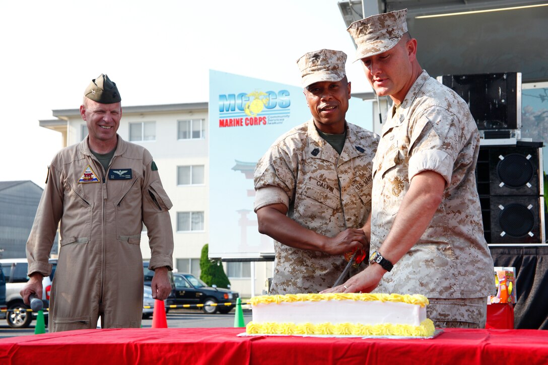Station commanding officer, Col. Michael O'Halloran, watches as Sgt Maj. David J. Wimberly, station sergeant major (right) and Sgt. Maj. Gerard J. Calvin, headquarters and headquarters squadron sergeant major, make the first cut into the Single Marine Program Hornet's Nest birthday cake at its 12th anniversary party here June 26.
