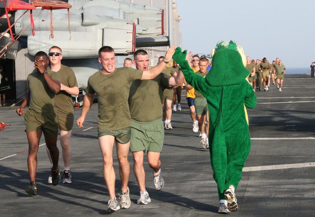 The USS Bataan (LHD 5) “Gator” mascot high-fives Marines from the 22nd Marine Expeditionary Unit during a 5K fun-run on Bataan’s flight deck June 26, 2009. Marines and Sailors from the 22nd Marine Expeditionary Unit and USS Bataan came together for a day of food, fun and games to build comradery during a scheduled deployment. The MEU, embarked aboard the ships of the Bataan Amphibious Ready Group, is currently serving as the theater reserve force for U.S. Central Command.