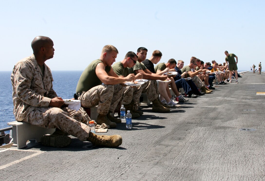 Marines and Sailors from the 22nd Marine Expeditionary Unit and USS Bataan (LHD 5) get a chance to relax and enjoy barbecue during a “Steel Beach” picnic on the flight deck of Bataan June 26, 2009. Marines and sailors came together for a day of food, fun and games to build comradery during a scheduled deployment. The MEU, embarked aboard the ships of the Bataan Amphibious Ready Group, is currently serving as the theater reserve force for U.S. Central Command.
