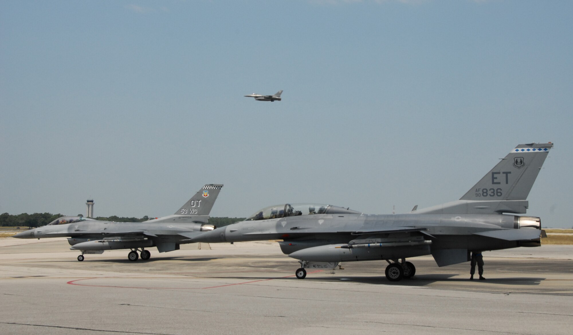 F-16s from the 53rd Wing (left) and the 46th Test Wing (right) arm up before take-off as another F-16 ascends overhead June 25 at Eglin Air Force Base Fla.  (U.S. Air Force photo/Samuel King Jr.)
