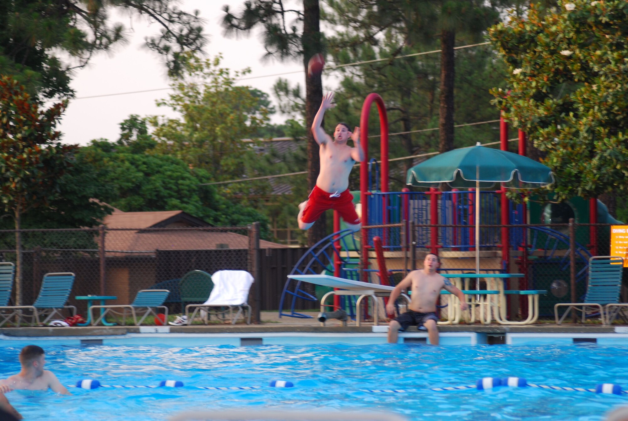 Airman 1st Class William Ainsworth, 43rd Communications Squadron, catches a football mid-air at June 19’s Dorm Pool Party.  Airmen residing in Pope dorms were invited out to enjoy an evening of music and fun as they celebrate summer at the Pope Pool.