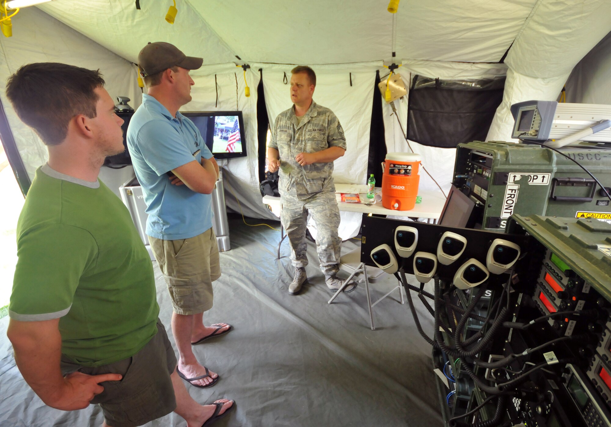 Chief Master Sgt.  Don Johnson of the 151st Communication Squadron, Utah Air National Guard, talks with Scott Stein of Murray (left) and Kelly Dansie of Salt Lake City, Utah about the Joint Incident Site Communication Center (JISCC) at Pioneer Park during Air Force Week June 1.  The JISCC allows the UTANG and Utah Army NG to provide communications with multiple government and civilian agencies during times of disasters by linking multiple radio frequencies and phone lines at the same time.   Pioneer Park in Salt Lake City was one of the locations for the public to meet and learn about the Air Force capabilities during AF Week June 1 ? 7, 2009.  U.S. Air Force photo by Tech. Sgt. Michael D Evans.

