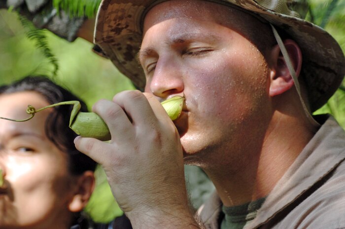 Petty Officer 1st Class Lawrence W. Comdeco drinks rainwater from a funnel plant during a search and rescue exercise held here, June 28 as part of exercise Air Warrior 2009. The search and rescue exercise allowed U.S. Marine Corps and Royal Malaysian Air Force pilots the opportunity to improve bilateral cooperation in a practical application of pilot survival and operational readiness.