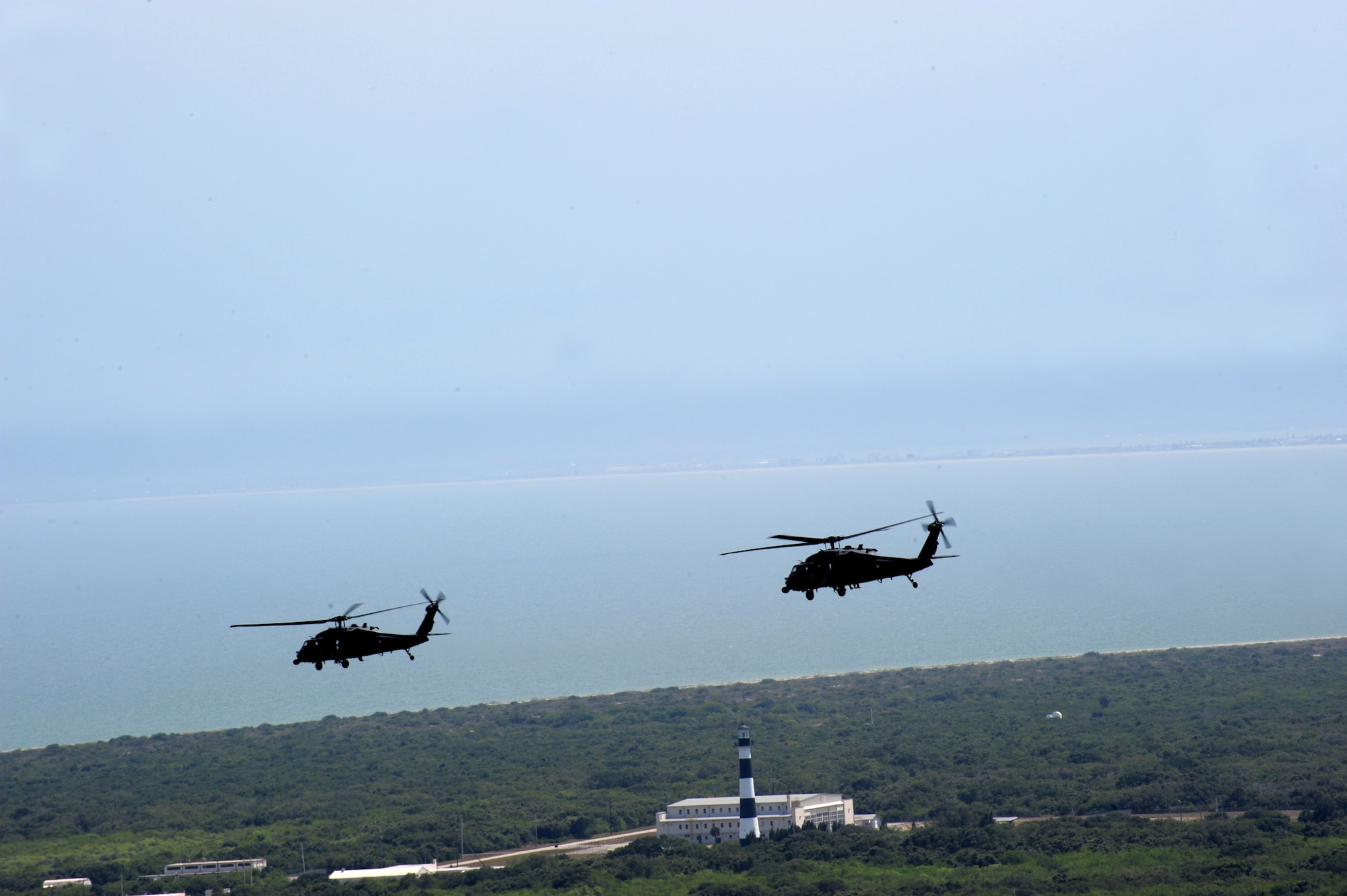 PATRICK AIR FORCE BASE, Fla. - From two to four HH-60G Pave Hawks piloted by Air Force Reservists of the 920th Rescue Wing here support every manned and unmanned rocket launch from Florida's spaceport. Seen here, the two helicopters race by the historic lighthouse over Cape Canaveral Air Force Station prior to launch support. (U.S. Air Force Photo/Tech. Sgt. Gillian M. Albro)