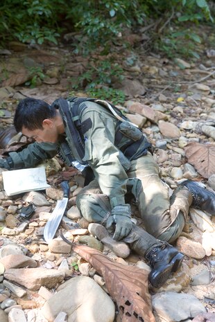 Royal Malaysian Air Force Capt. Mohd Azizi bin Musa checks his map to verify he and Marine All-Weather Fighter Attack Squadron 225 1st Lt. Steve Bradford are heading the correct direction to reach the landing zone during a search and rescue exercise here June 28. Although the pilots were permitted to the have a map, they could only use it for approximating their location since the map only identified the road and river which they were not able to follow for concealment purposes.