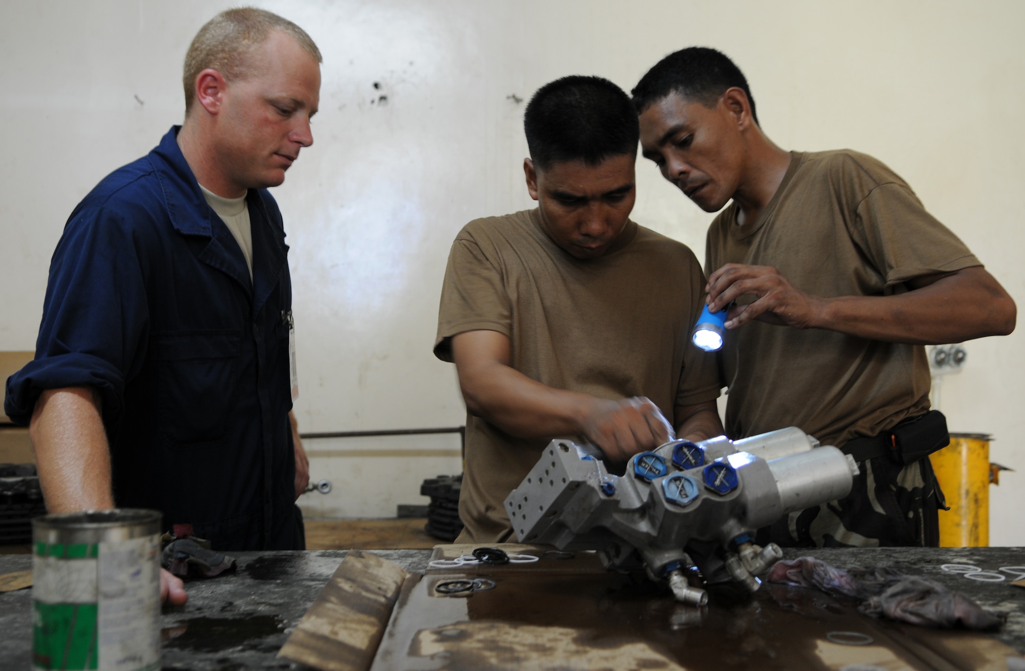 MACTAN AIR BASE, Philippines -- Tech. Sgt. Dennis Henderson, a 353rd Maintenance Squadron member, watches members of the Philippine Air Force remove seals from a hydraulic boost pack here June 22.  Five maintainers from the 353rd MXS conducted a two-week training exchange with multiple PAF C-130 maintenance units during Teak Piston 09-2, a training exchange designed to enhance U.S and Philippine military training, capabilities and increase interoperability. (U.S. Air Force Photo by Tech. Sgt. Aaron Cram)