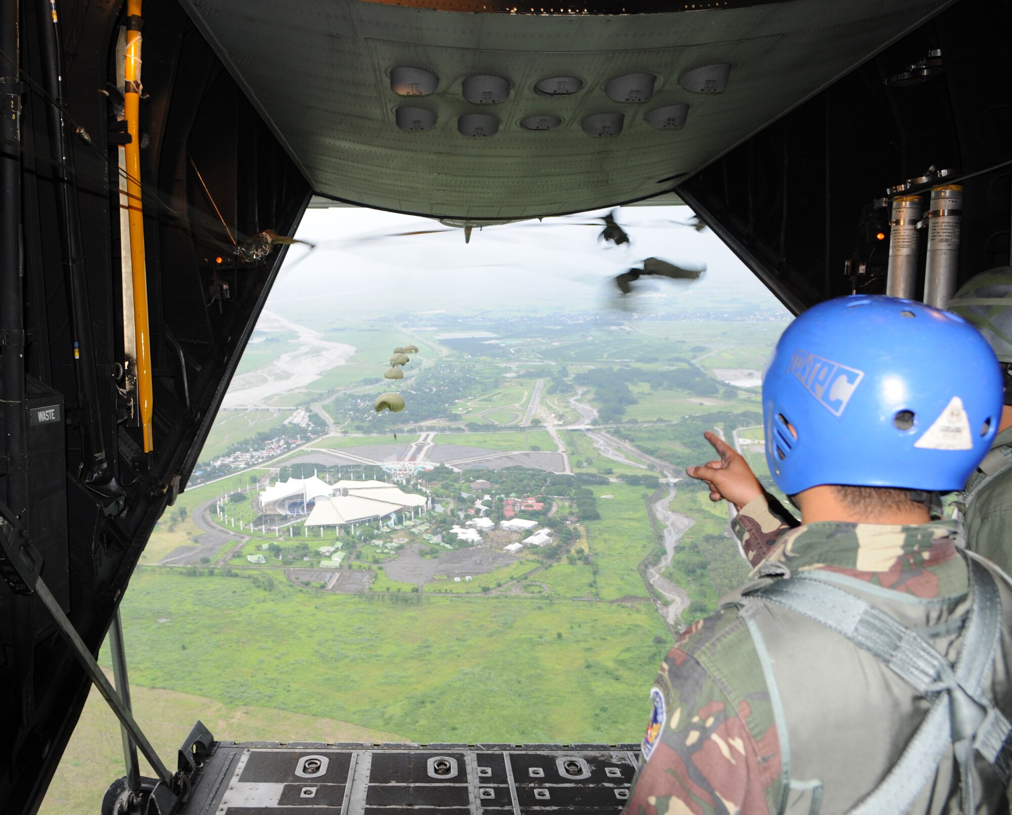 CLARK AIR BASE, Philippines -- A jumpmaster from the Philippine Air Force counts parachutes opening after a static-line personnel drop from a 17th Special Operations Squadron MC-130P Combat Shadow here June 19.  About 90 members from the 353rd Special Operations Group trained with the Philippine Air Force June 15-26 during Teak Piston 09-2, a training exchange designed to enhance U.S and Philippine military training, capabilities and increase interoperability. (U.S. Air Force Photo by Tech. Sgt. Aaron Cram)
