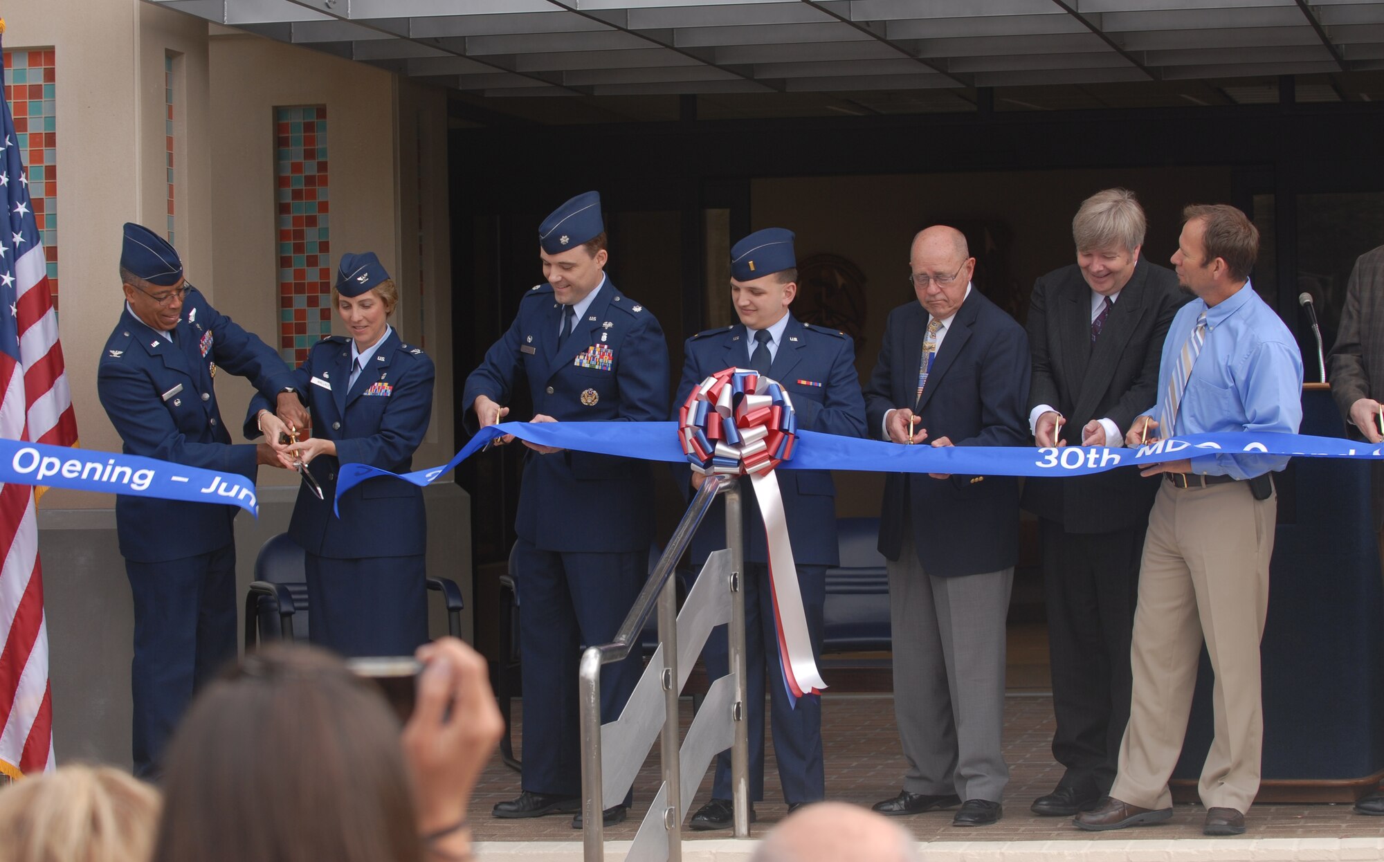 VANDENBERG AIR FORCE BASE, Calif. -- Members from the 30th Medical Group celebrate the grand opening of their new clinic here by cutting the ribbon leading to an entrance to the building. The 30th MDG celebrated the opening of their new clinic here June 29 after all renovations had been completed. (U. S. Air Force photo/Senior Airman Antoinette Lyons)