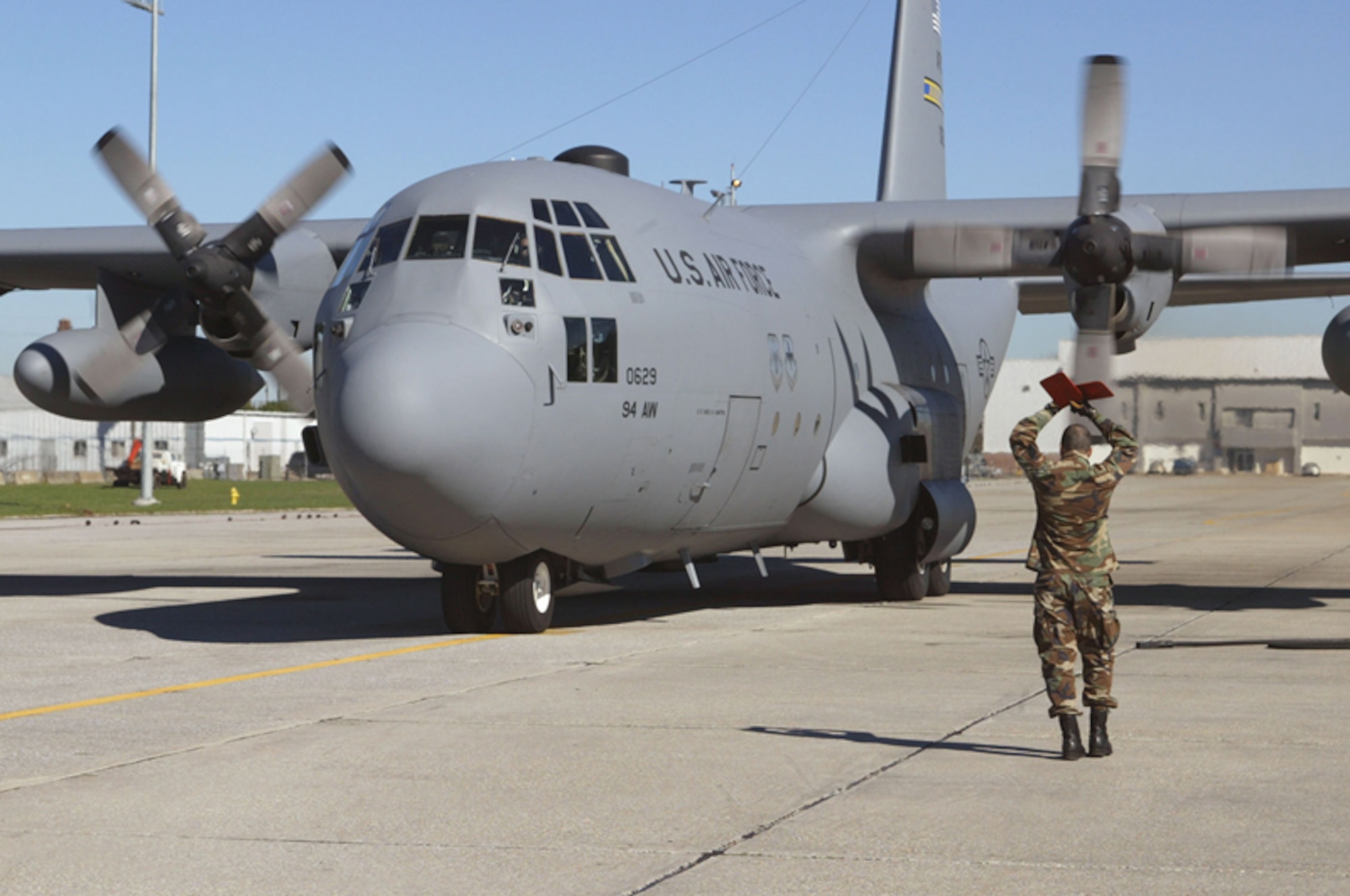 A member of the Airlift Control Flight marshals a C-130 after a training mission at Dobbins Air Reserve Base. (U.S. Air Force photo/Don Peek)
