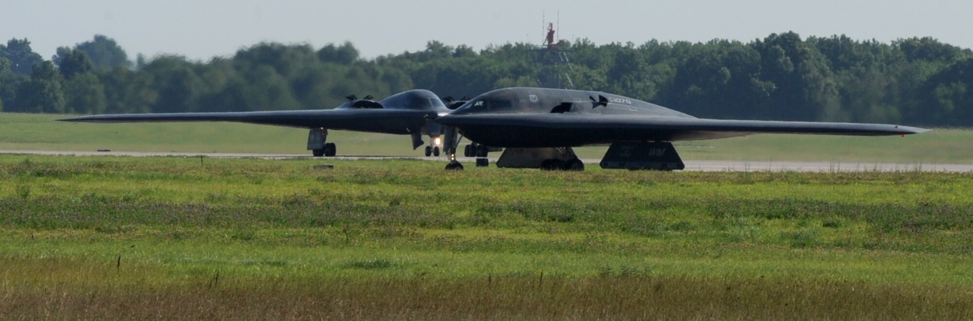WHITEMAN AIR FORCE BASE, Mo. -Two B-2 Stealth Bombers strut their stuff as they taxi off the runway after completing training,  June 29. The multiple aircraft fly off is part of the 509th Bomb Wing's training to provide maximum efficiency in the launching of aircraft. (U.S. Air Force photo/Airman 1st Class Carlin Leslie)