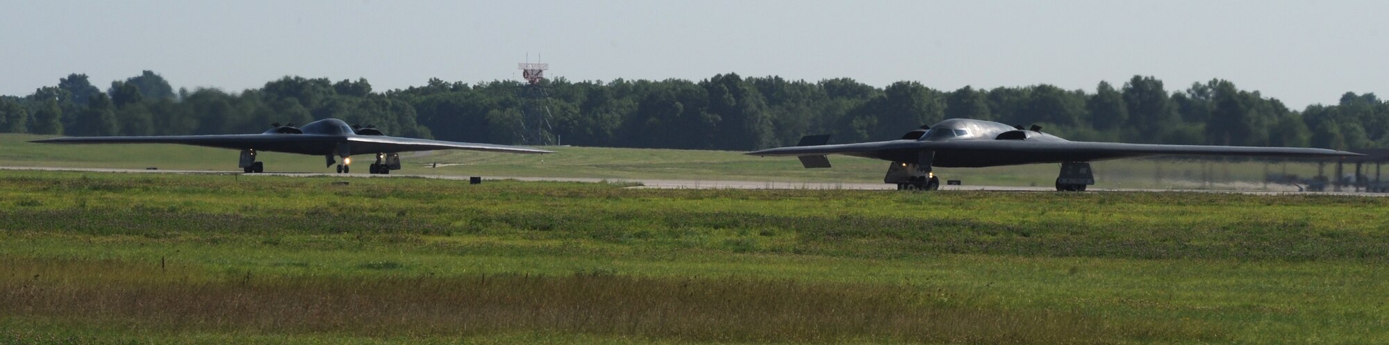 WHITEMAN AIR FORCE BASE, Mo. - A B-2 Stealth bomber turns to taxi off the runway as another is following close behind June 29. The multiple aircraft fly off is part of the 509th Bomb Wing's training to provide maximum efficiency in the launching of aircraft. (U.S. Air Force photo/Airman 1st Class Carlin Leslie)