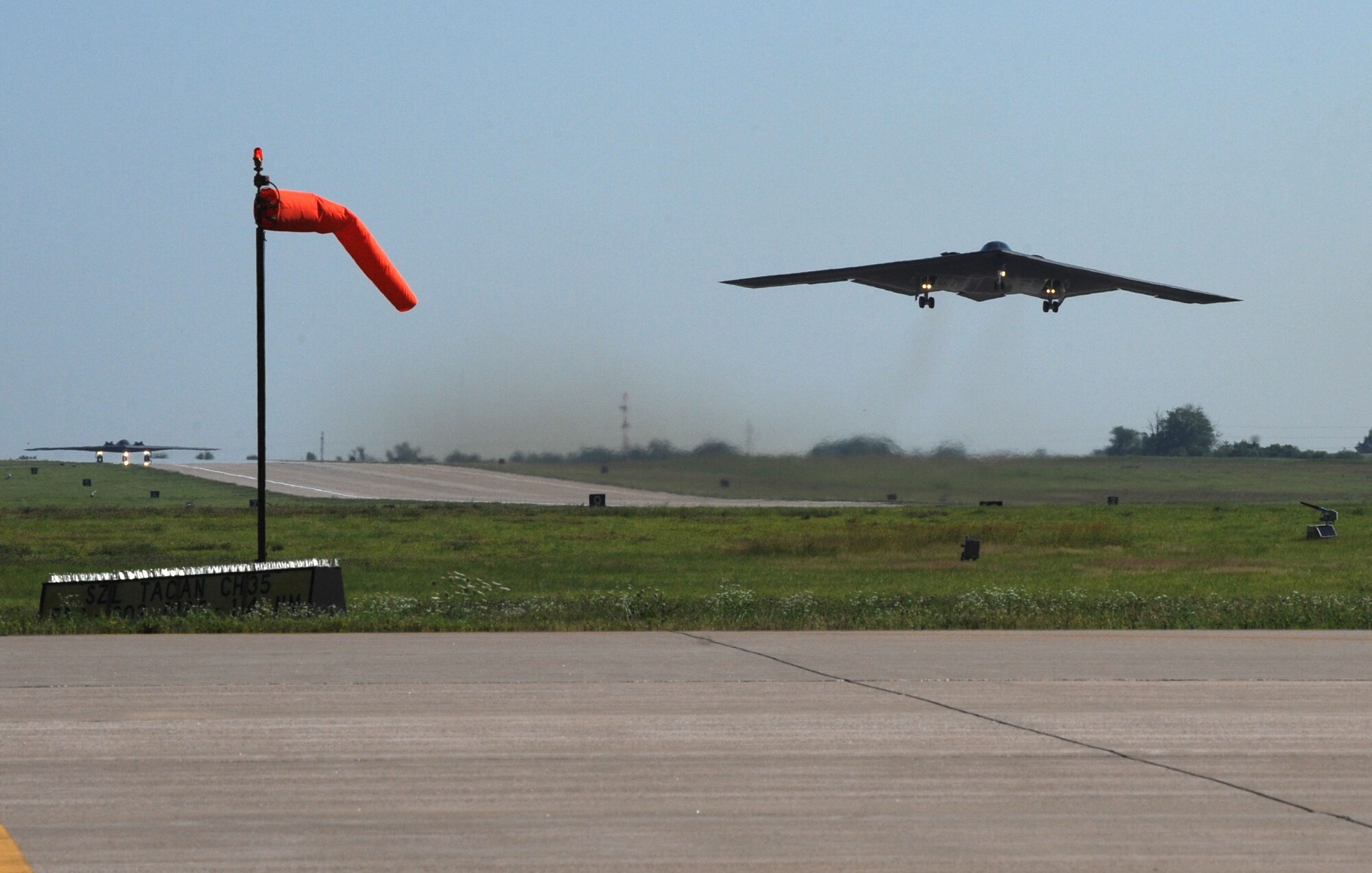 WHITEMAN AIR FORCE BASE, Mo. - A B-2 bomber takes off early morning at full throttle, June 29, while another B-2 waits at the other end of the runway. The B-2 Stealth’s are participating in day-to-day operations at Whiteman Air Force Base. (U.S. Air Force photo/Airman 1st Class Carlin Leslie)