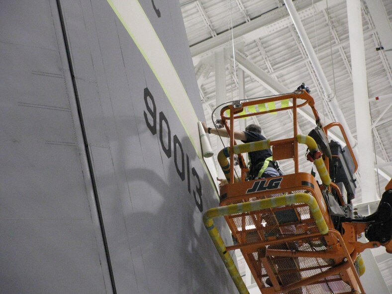 WRIGHT-PATTERSON AFB, Ohio - Tech. Sgt. Aaron Bullucks and Tech. Sgt. Kerry Penner, both of the 445th Maintenance Squadron, prepare one of the 445th Airlift Wing's C-5 Galaxies for a new tail flash design.  The new design was created by 445th personnel. (Courtesy photo)