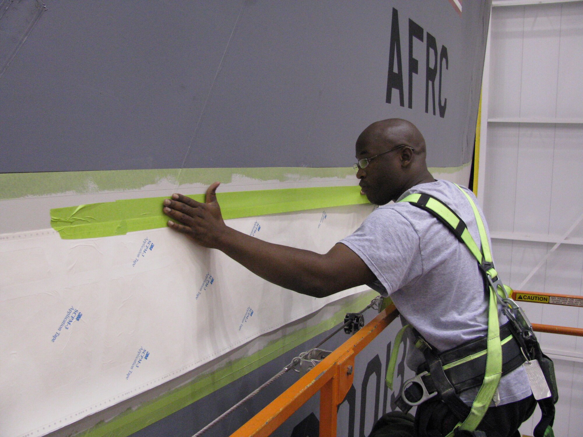 WRIGHT-PATTERSON AFB, Ohio - Tech. Sgt. Aaron Bullucks, 445th Maintenance Squadron, prepares one of the 445th Airlift Wing's C-5 Galaxies for a new tail flash design.  The new design was created by 445th personnel. (Air Force photo/Tech. Sgt. Kerry Penner)