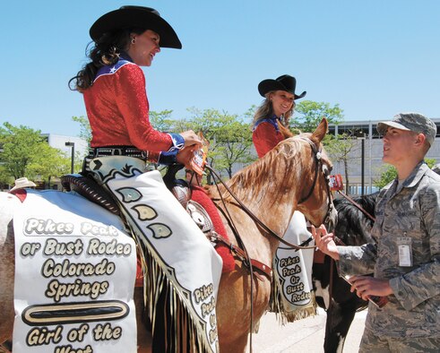 Cadet 3rd Class Jared Barkemeyer, right, talks to April Biernat, the 2009 Girl of the West, during her visit to the U.S. Air Force Academy in Colorado Springs, Colo., June 22. The Girl of the West and her aide, Jessica Greene, toured the Academy to promote the 2009 Pikes Peak or Bust Rodeo. (U.S. Air Force photo/Denise Navoy)
