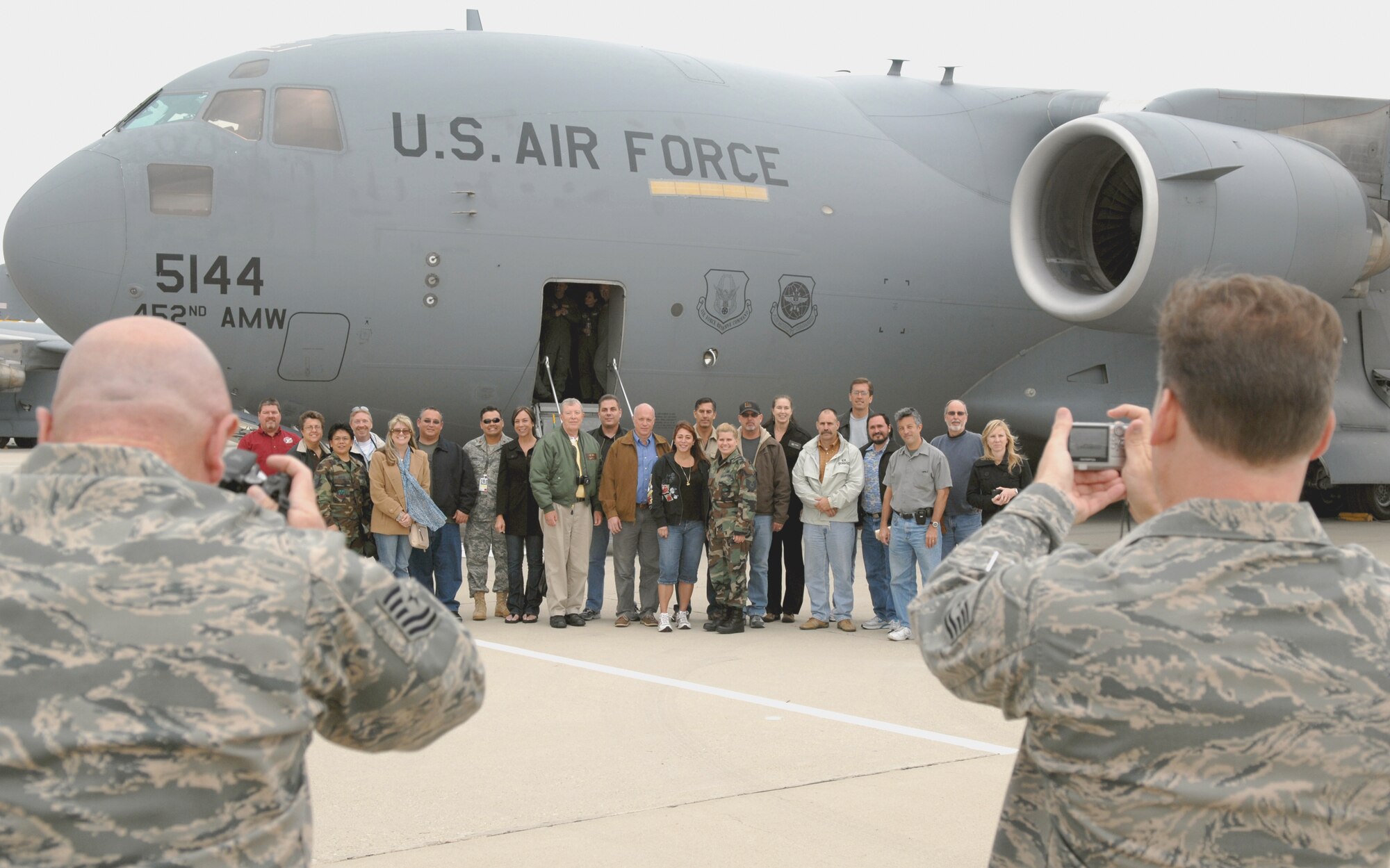 Tech. Sgt. Joe Davidson, left, and Master Sgt. Mike Blair, public affairs specialists from the 452nd Air Mobility Wing, take photos of reservists’ employers next to a C-17A Globemaster III, from the 729th Airlift Squadron, during the Employers Appreciation Day. The flight was the second and final Employers  Flight of the year.   (U. S. Air Force photo by Master Sgt. Rick Sforza)