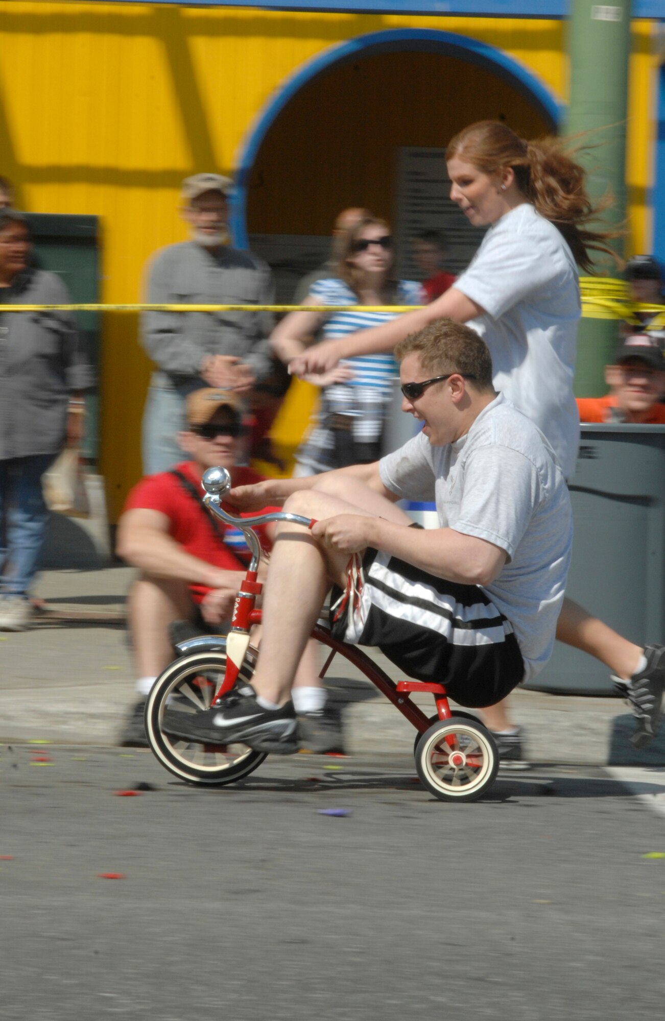 ANCHORAGE, Alaska -- Senior Airman Ryan Blanton rides a tricycle to the finish line during the 2009 Hero Games June 27. Hero Games brought military and civilian teams together in a friendly competition of various games such as water balloon volleyball, tug o' war and litter carry. Blanton is a member of the 703rd Aircraft Maintenance Squadron. (U.S. Air Force photo/Senior Airman David Carbajal)