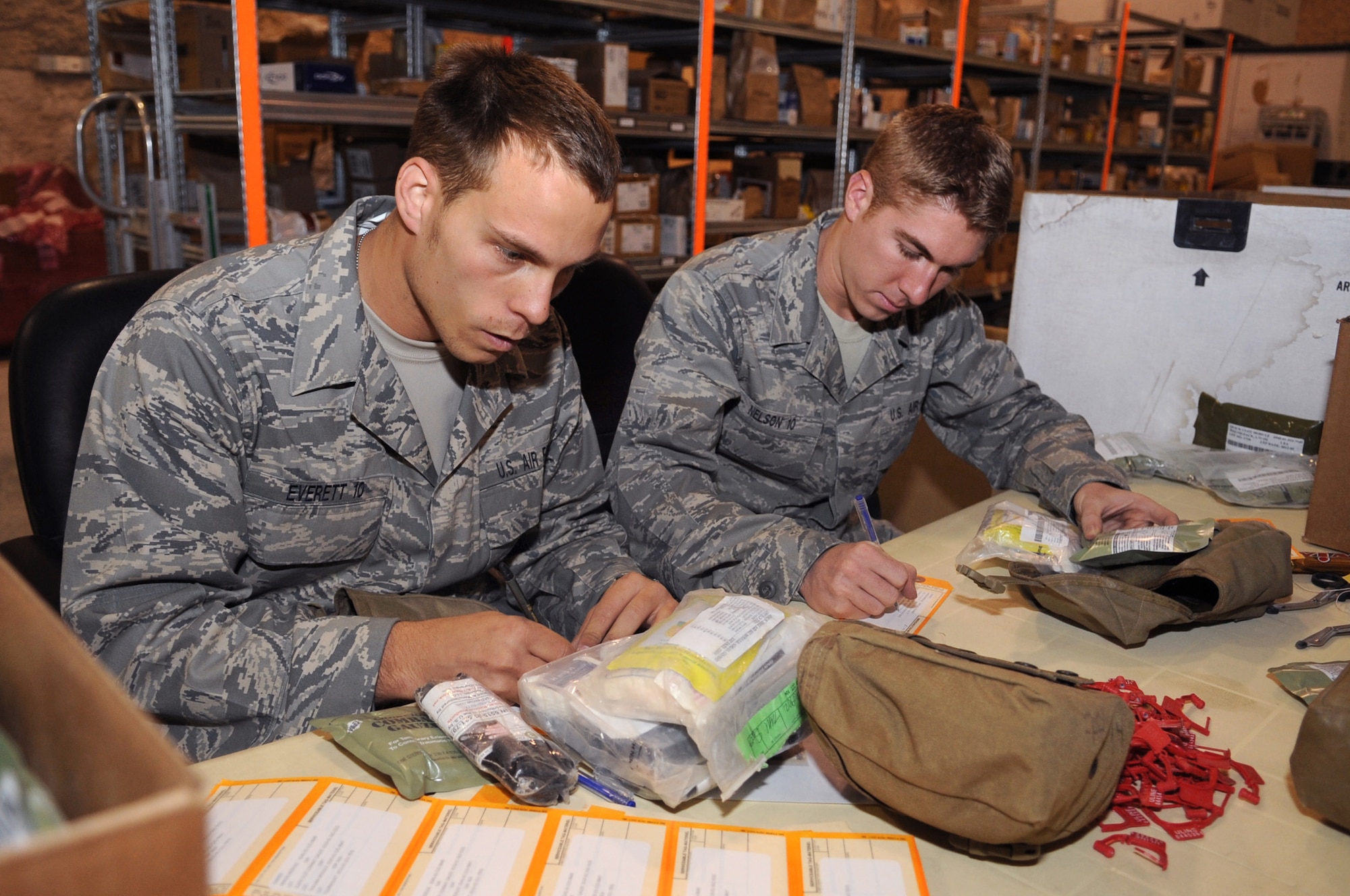 Air Force Cadets Dan Everett and Erik Nelson, build Individual First Aid Kits for deploying members heading downrange, while visiting the 379th Expeditionary Medical Group facilities, June 25, 2009, in an undisclosed location in Southwest Asia.  The cadets are part a program called Operation Air Force, which gives them exposure to the operational side of the Air Force before being commissioned. Cadet Everett hails from Isanti, Minn. and Cadet Nelson is from Montville, Conn., both are visiting from the Air Force Academy, Colo. to gain knowledge about Operations Iraqi and Enduring Freedom and Combined Joint Task Force - Horn of Africa.  (U.S. Air Force Photo by Staff Sgt. Joshua Garcia/released) 