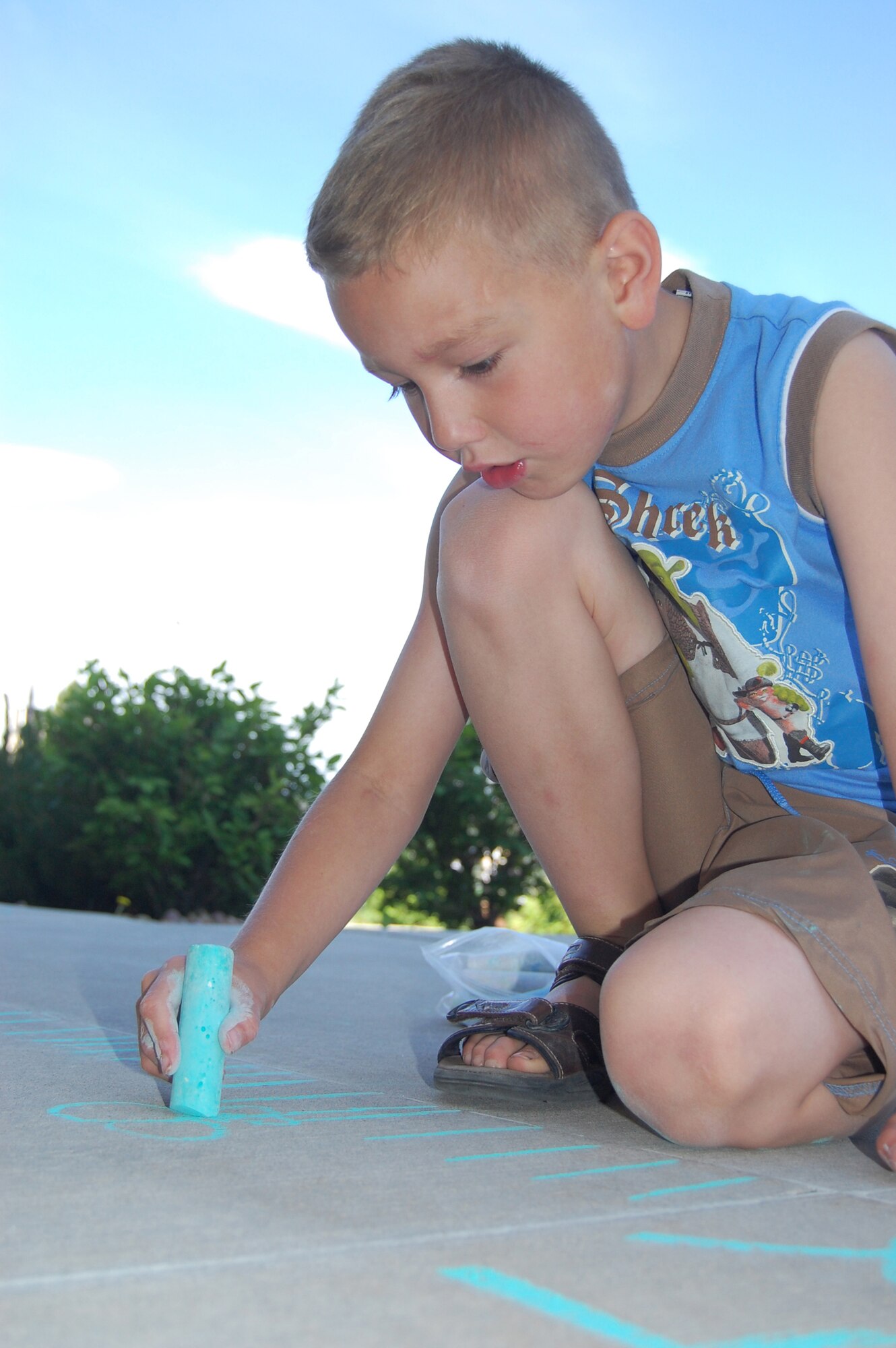 Little Warrior Christian, 7, works on his chalk artwork June 19 as part of the 10th Annual Chalk-It Up sidewalk art competition in the Youth Program Center parking lot. (U.S. Air Force photo/Staff Sgt. Marcus McDonald)