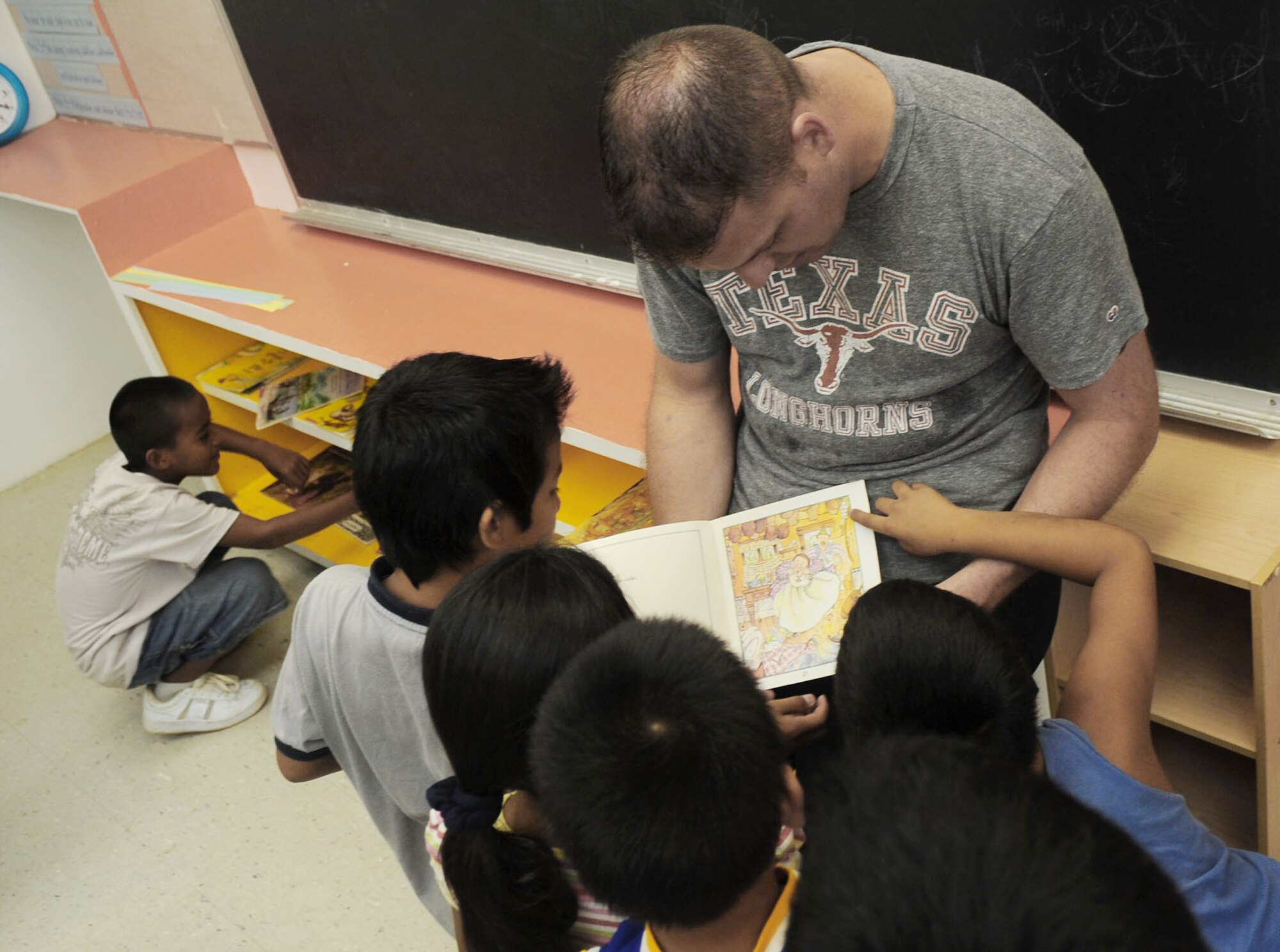 Staff Sgt. Frank Ruckel reads to some of the third and fourth graders June 19 at Machananao Elementary School in Agana, Guam. The Dripping Springs, Texas, native is deployed to Andersen Air Force Base, Guam, from Elmendorf AFB, Alaska, to support U.S. Pacific Command's continuous bomber presence in the Asia-Pacific Region. Sergeant Ruckel is a 3rd Expeditionary Maintenance Unit aircraft metals technologist. (U.S. Air Force photo/Senior Airman Christopher Bush)