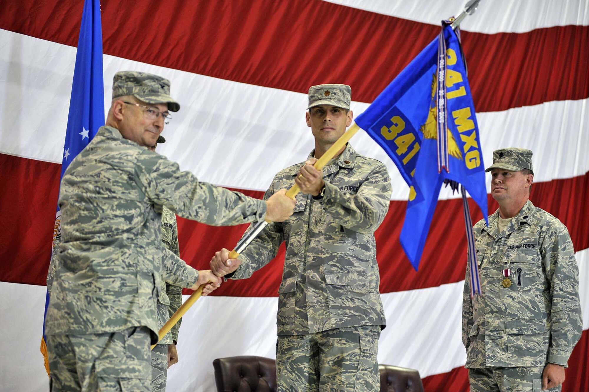 Maj. Richard Cross, center, accepts command of the 341st Maintenance Operations Squadron from 341st Maintenance Group Commander Col. Jeffrey Frankhouser June 18 at the 3-Bay Hangar.  Outgoing 341st MOS Commander Lt. Col. Richard Allen looks on. (U.S. Air Force photo/John Turner)